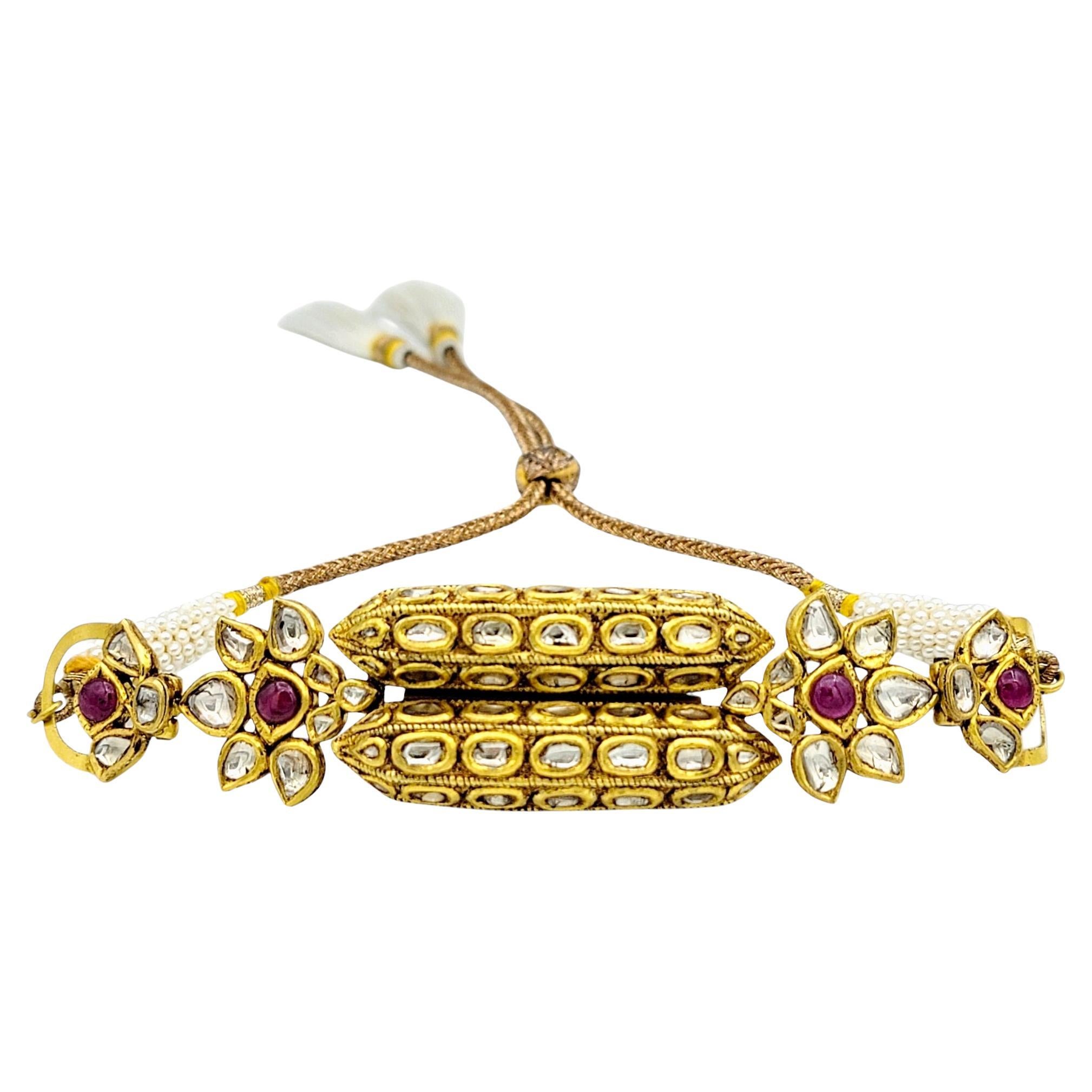 This breathtaking bracelet is a true testament to heritage craftsmanship and regal elegance. Showcasing luminous rose-cut Polki diamonds, rich cabochon rubies, and delicate freshwater pearls, this piece radiates old-world charm with a refined,