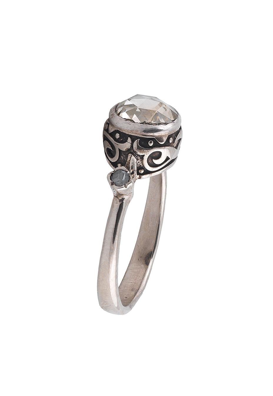 

A rose-cut diamond single-stone ring
The rose-cut diamond in closed back setting to openwork gallery and decorated hoop 
Size 7