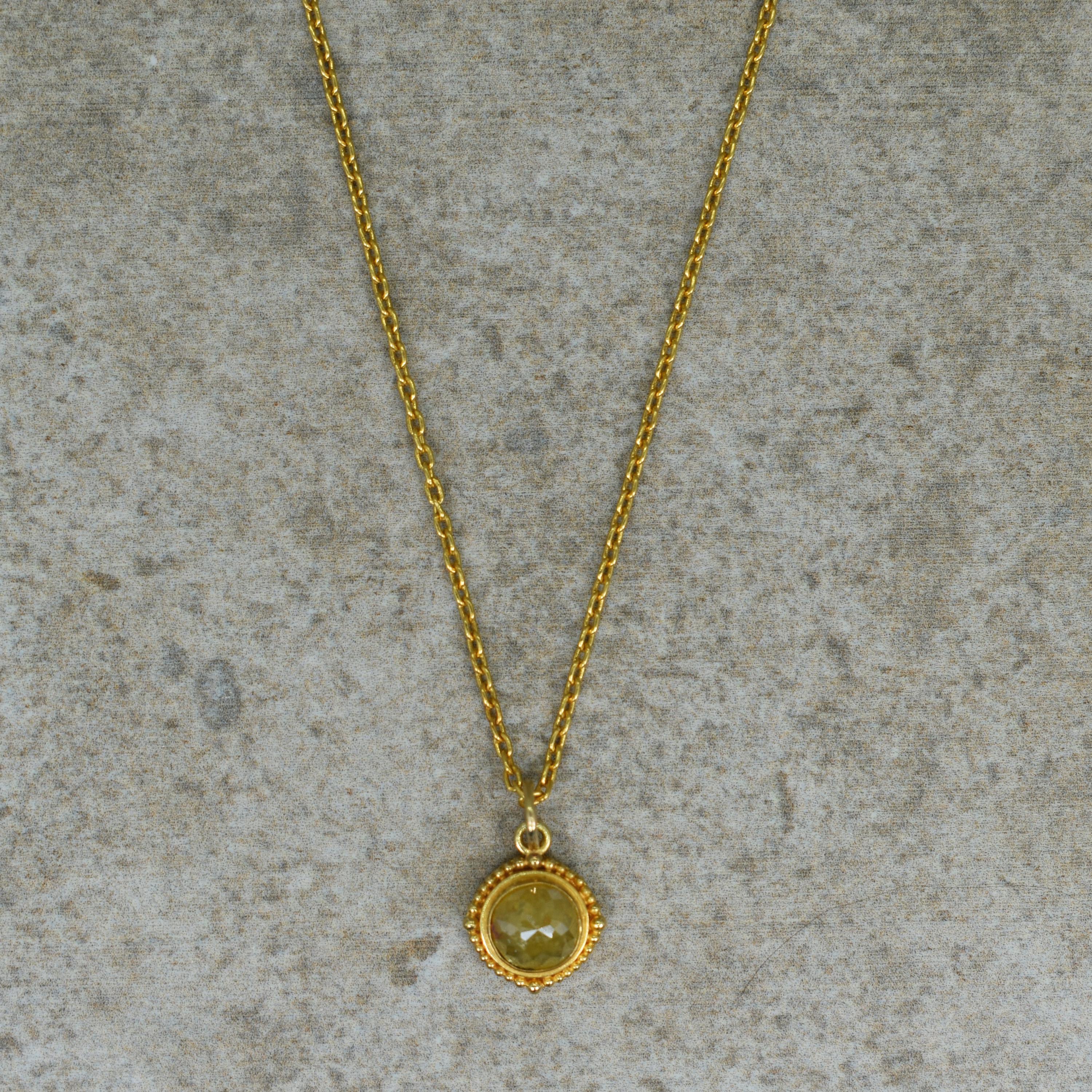 Grüner Rohdiamant im Rosenschliff, 18 Karat Gelbgold, Anhänger an einer Kette aus 24 Karat Gelbgold. Der Anhänger ist 18 mm lang (0,69 Zoll), einschließlich Bügel. Die Kette ist 18 Zoll lang und wird mit einem Knebelverschluss geschlossen. 
