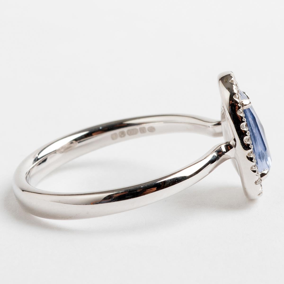 A delightful delicately worn piece, a rose cut pale blue sapphire 4 claw dress ring with twenty three micro set diamond halo all in 18k white gold. the sapphire est 1.16carat, the diamonds combined .11carat. This ring is hallmarked London 2019 and