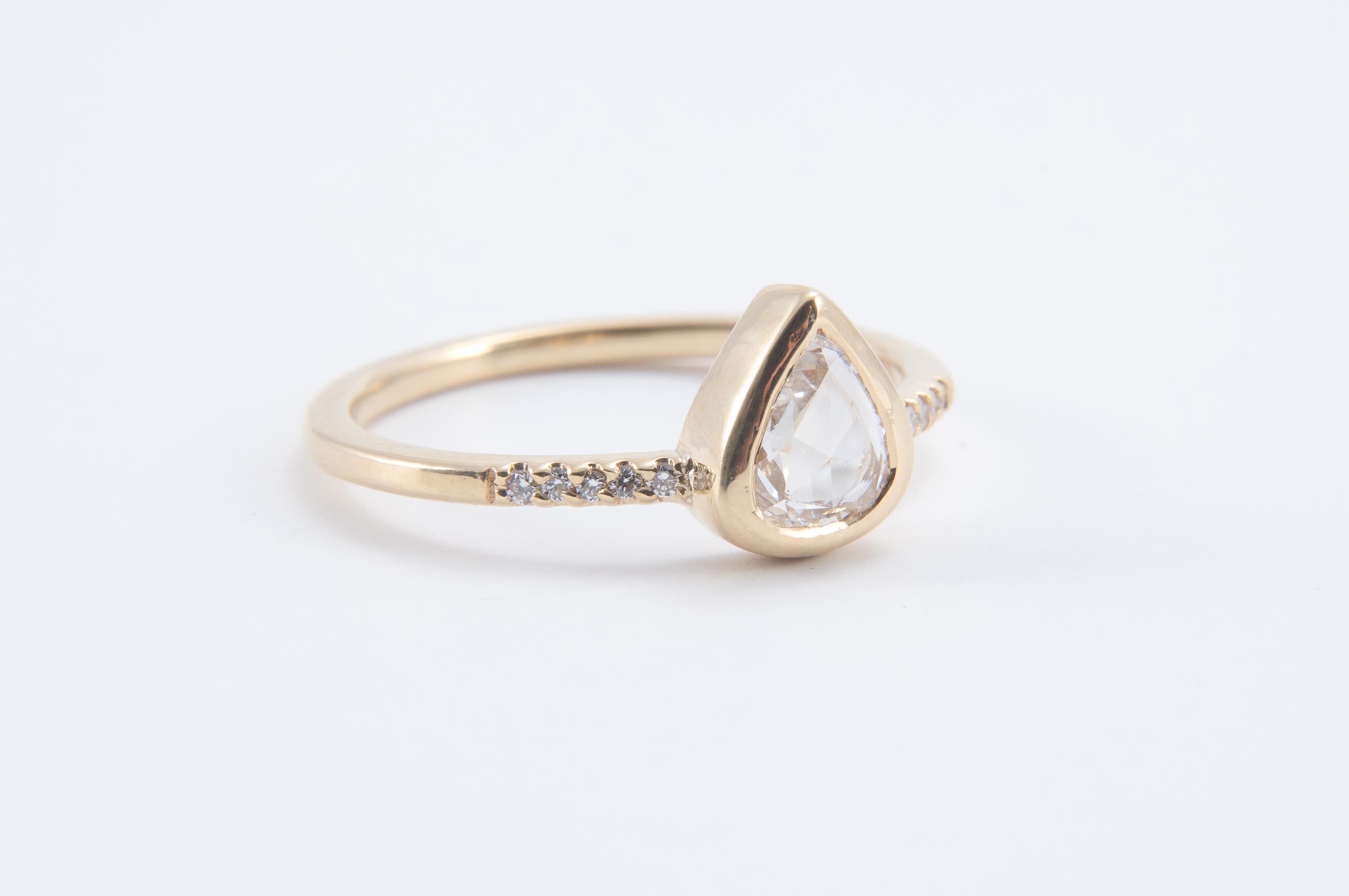 A stunning pear-shaped champagne diamond sits between glistening pave set white diamonds.

Perfect on its own as a subtle statement piece or stacked.

18K yellow gold band featuring a central 0.60ct pale champagne rose cut diamond set between 0.06ct