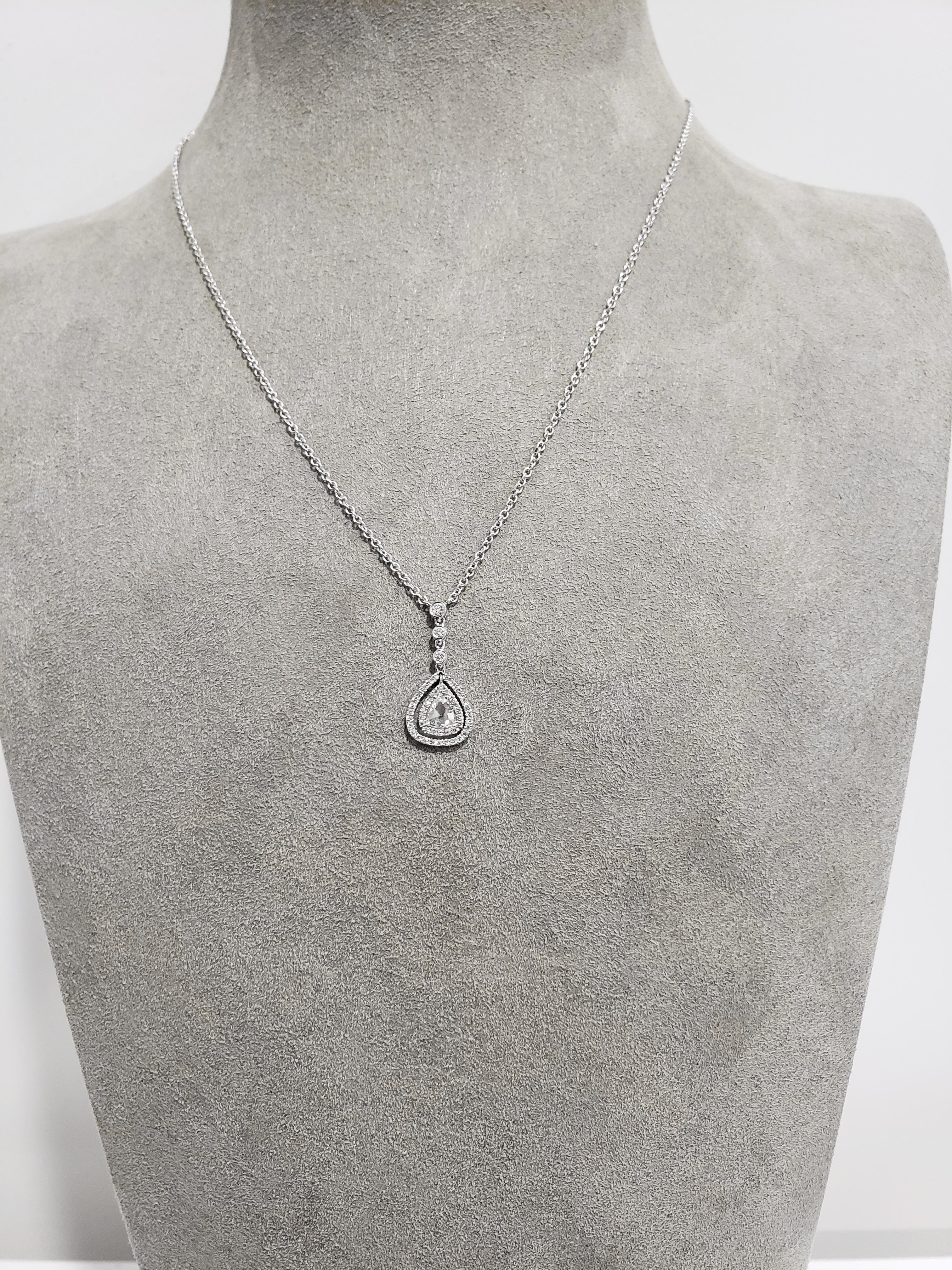 Un singolo diamante taglio rosa da 0,40 carati circondato da due file di diamanti rotondi in un design traforato. Sospeso su 3 diamanti rotondi, incastonati in oro bianco 18 carati. Attaccato a una catena in oro bianco 14 carati regolabile a 16 e 18