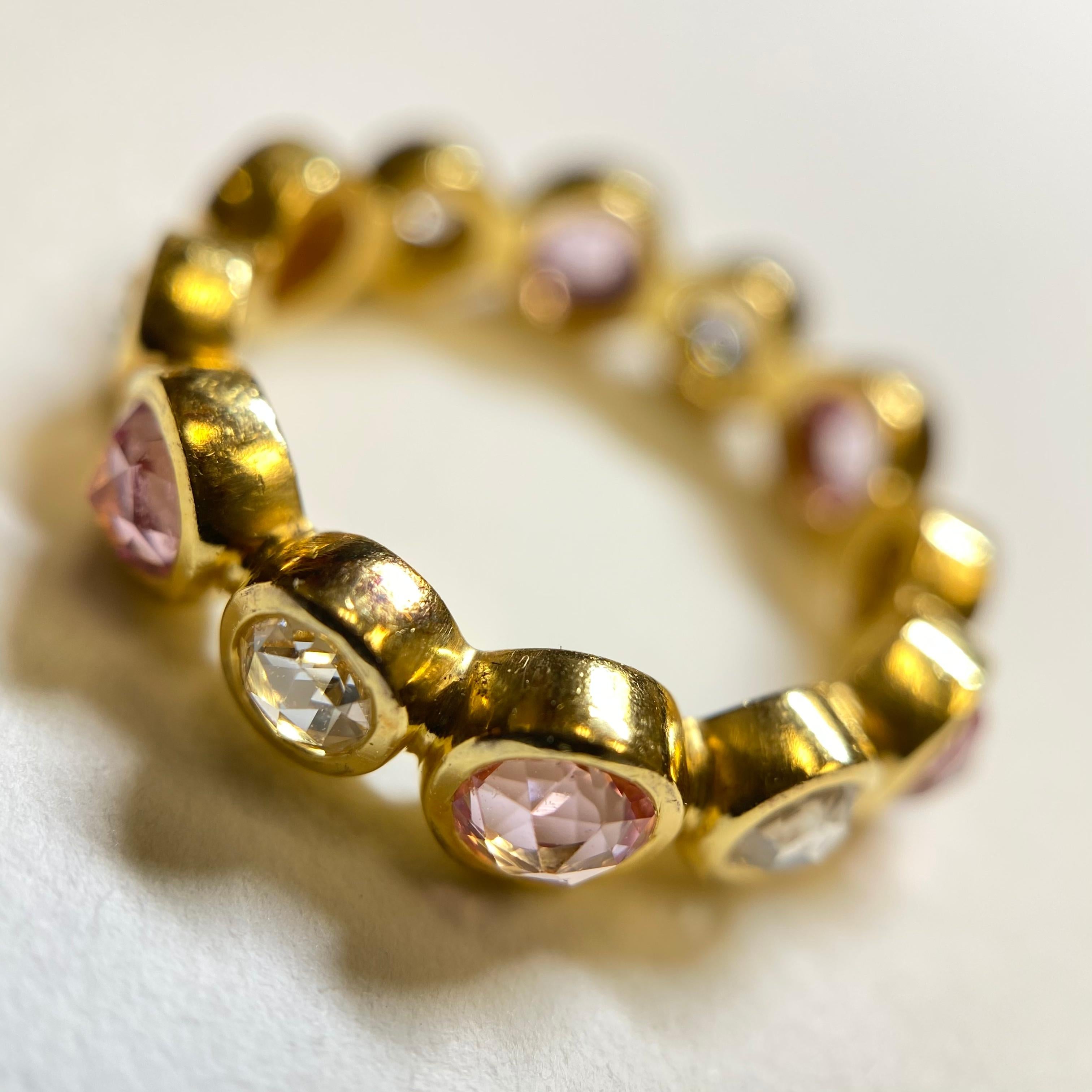 This sophisticated and feminine ring is set with alternating Rose Cut Diamonds and custom-cut Rose Cut Pink Sapphires. 
Rose Cut Diamonds were made popular in the Georgian Era (the 1700's), and have re-emerged as an ethereal, antique-inspired