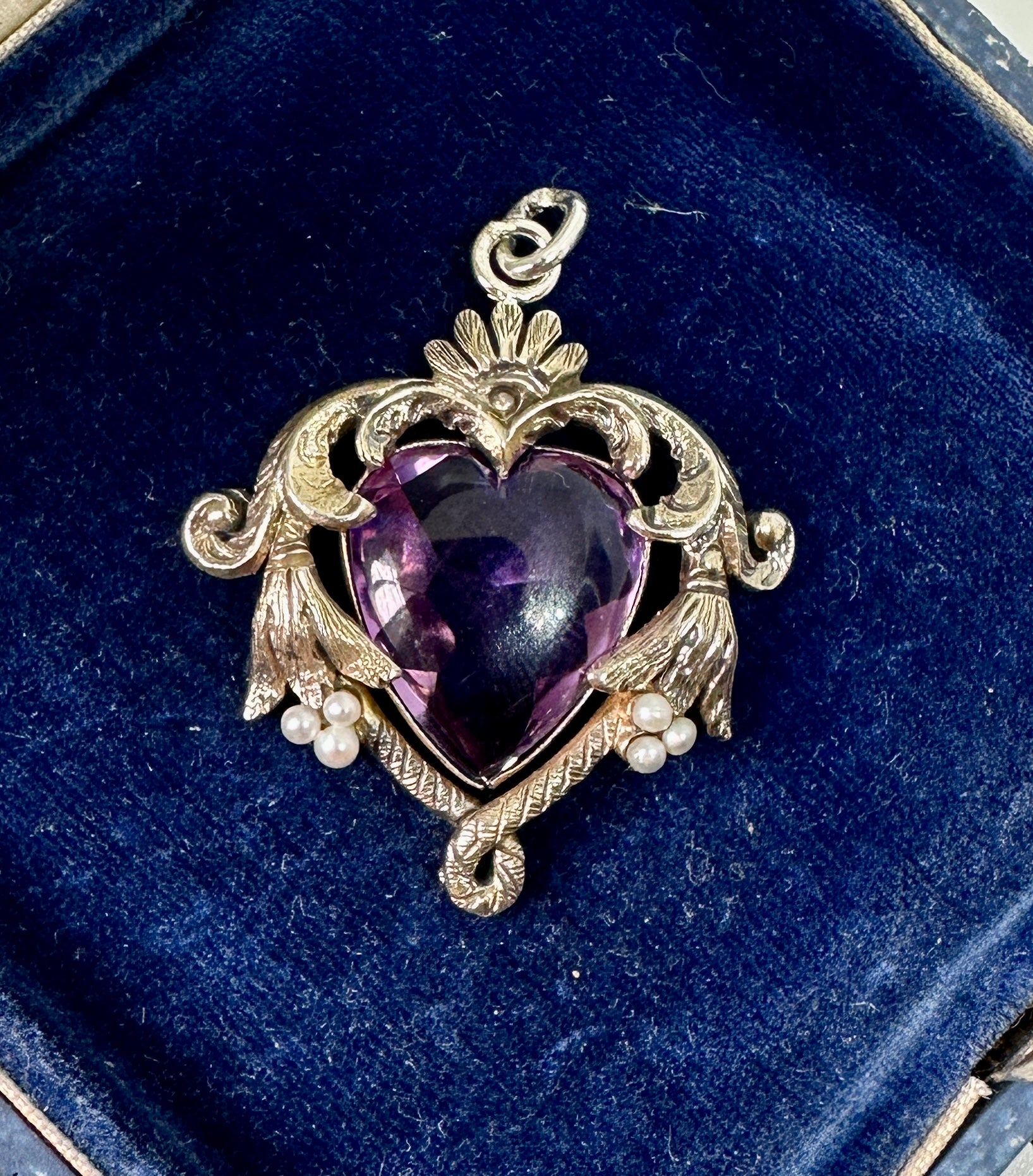 This is a magnificent Art Nouveau Pendant Necklace in Sterling Silver with a gorgeous Heart Shape Rose De France Amethyst in the center with Pearl adornments and dating to circa 1900. 
The central Rose de France Amethyst is a stunning heart shape