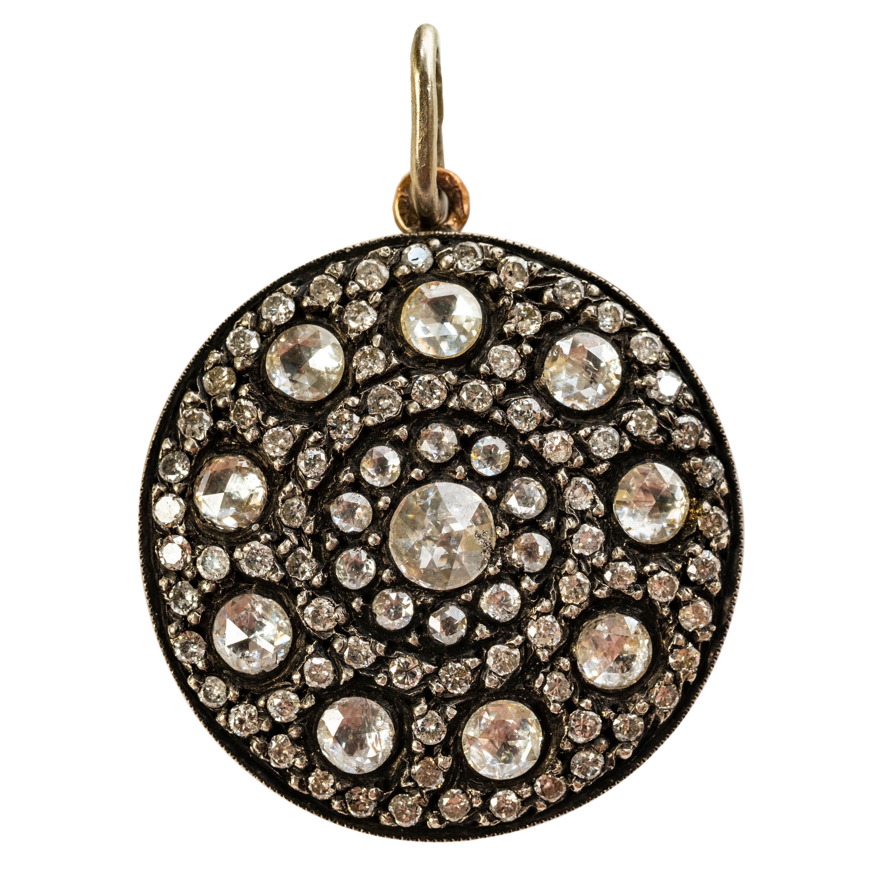 A beautiful diamond encrusted pendant recalling Ancient Muscovy densely set with co-centric bands of rose diamonds, mounted in silver and 9k rose gold, the reverse depicting stylized floral repoussé motifs. 

With French control marks. Chain not