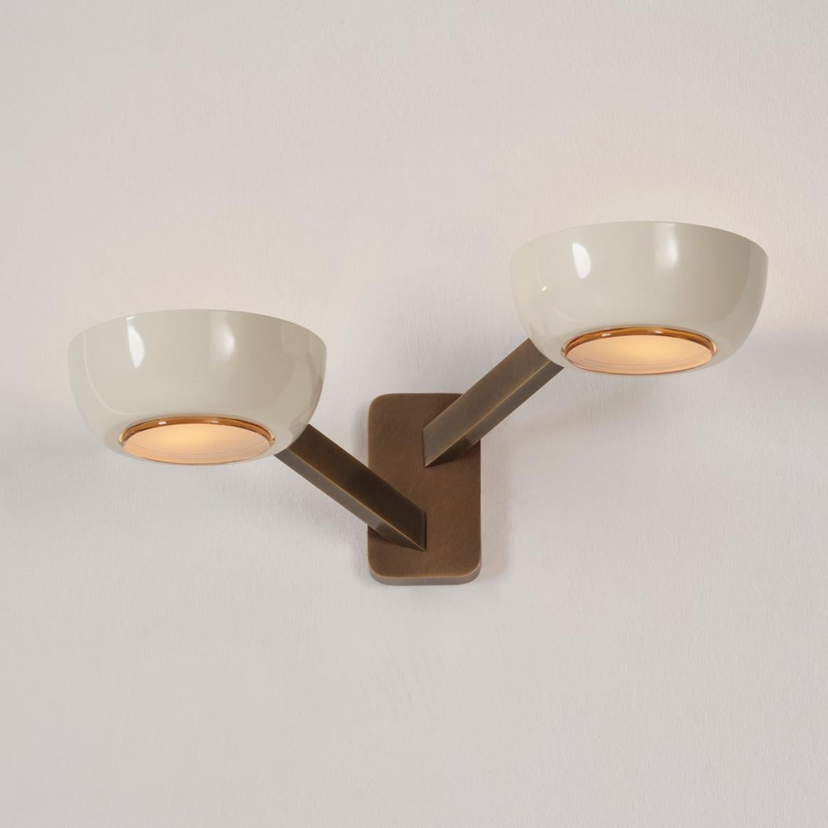 L'applique murale Rose Double, dotée de deux abat-jours décalés sur un cadre en laiton, se prête à la personnalisation grâce à la possibilité de changer la couleur de l'abat-jour, le diffuseur en verre et la finition du cadre. Voir les plafonniers