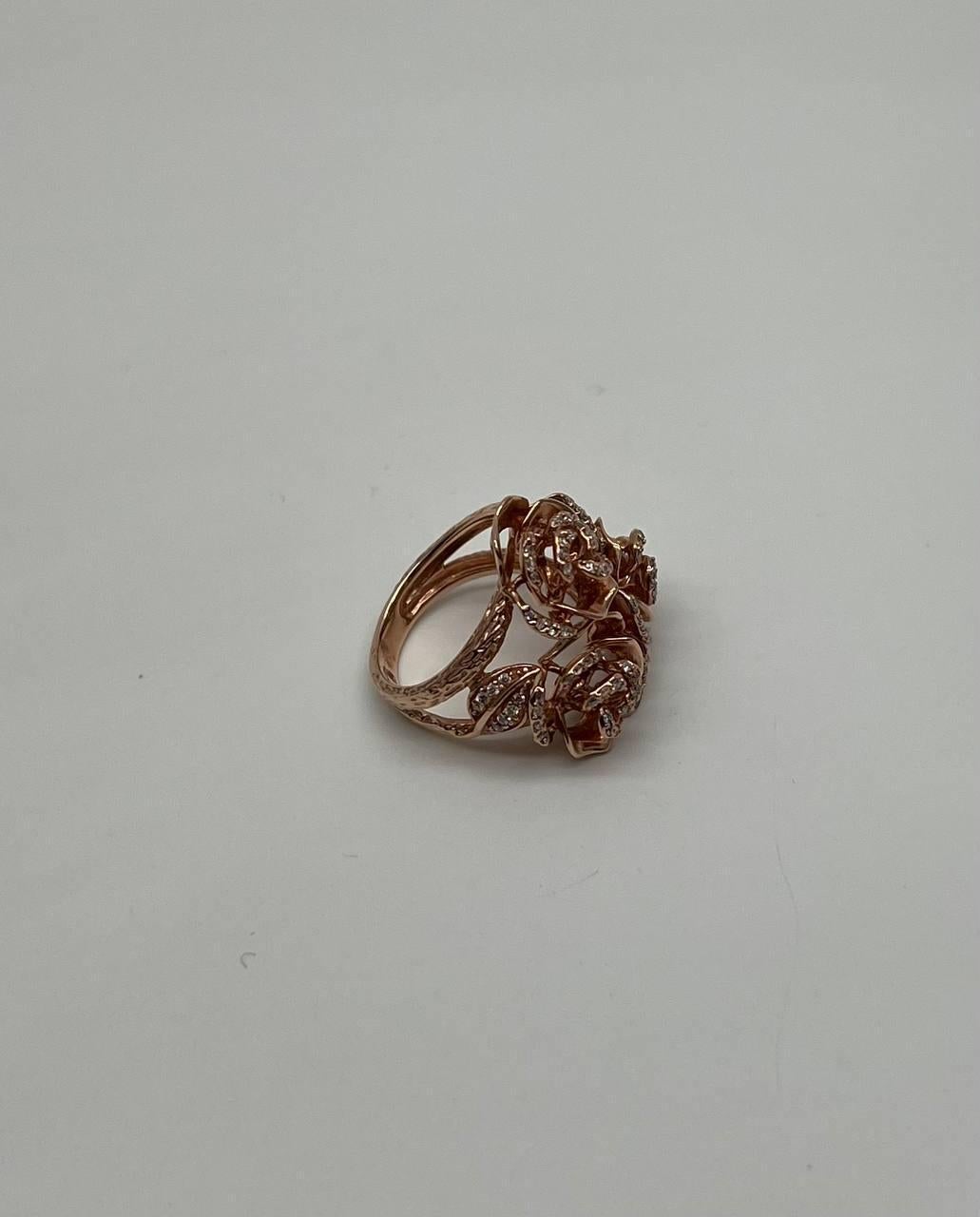 This remarkable piece features a delicate rose motif, intricately designed with shimmering diamonds that highlight its elegance. The openwork design allows light to dance through, enhancing the brilliance of each stone. The ring's sculptural form