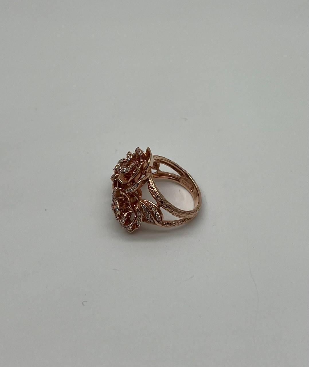 A floral symphony in gold and diamonds. This exquisite ring features an intricate design of blooming roses. Each rose is delicately crafted in gold, adorned with sparkling diamonds that catch the light beautifully. The openwork design allows for a