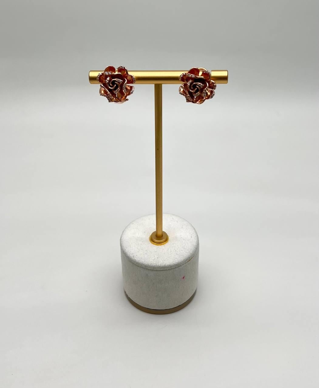 Discover the charm of these exquisite earrings. Crafted with intricate floral designs, these earrings feature a captivating blend of red and gold hues. The delicate petals are meticulously detailed, creating a striking visual appeal. 14K Rose Gold.