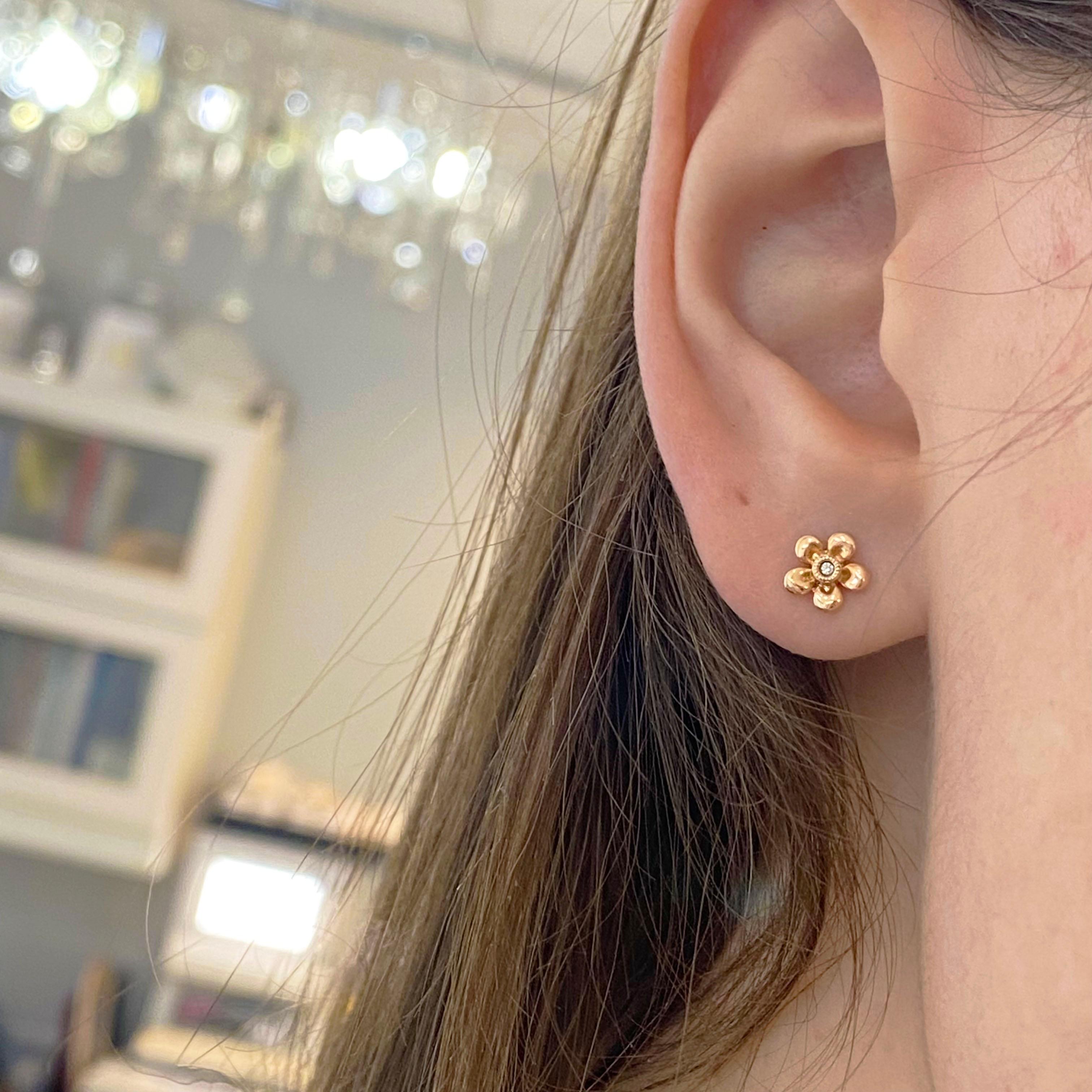 Rose gold earrings are so beautiful and this pair is in the shape of a flower with a center diamond brightening its sparkle. This minimalist look is precious on a delicate earlobe or when paired with multiple earrings. This is also our number one