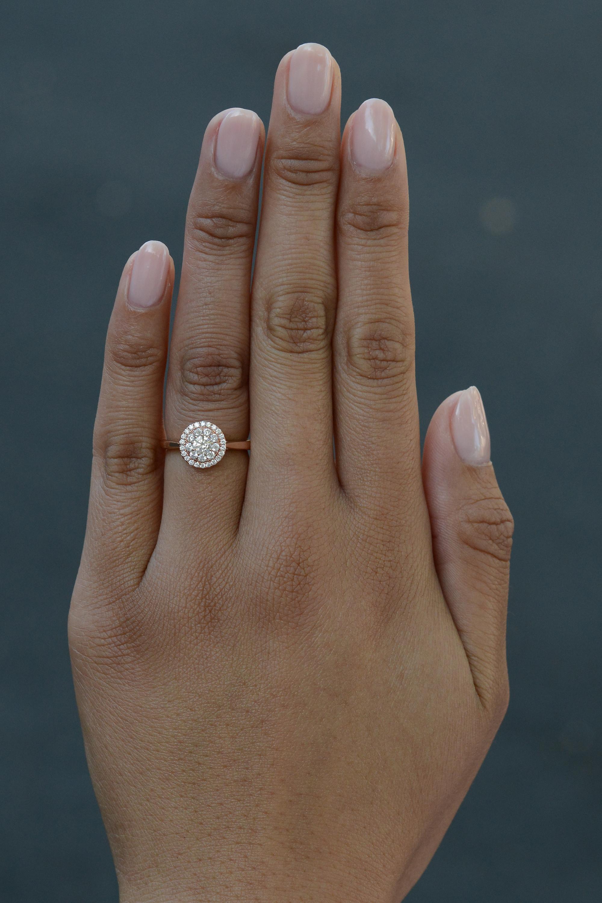 An elegant cluster diamond 1/2 carat engagement ring, offering small production sustainability and modern glamour. The crystalline clarity of VVS2  diamonds well matched by a classy 14 karat rose gold setting. An elegant halo of round diamonds