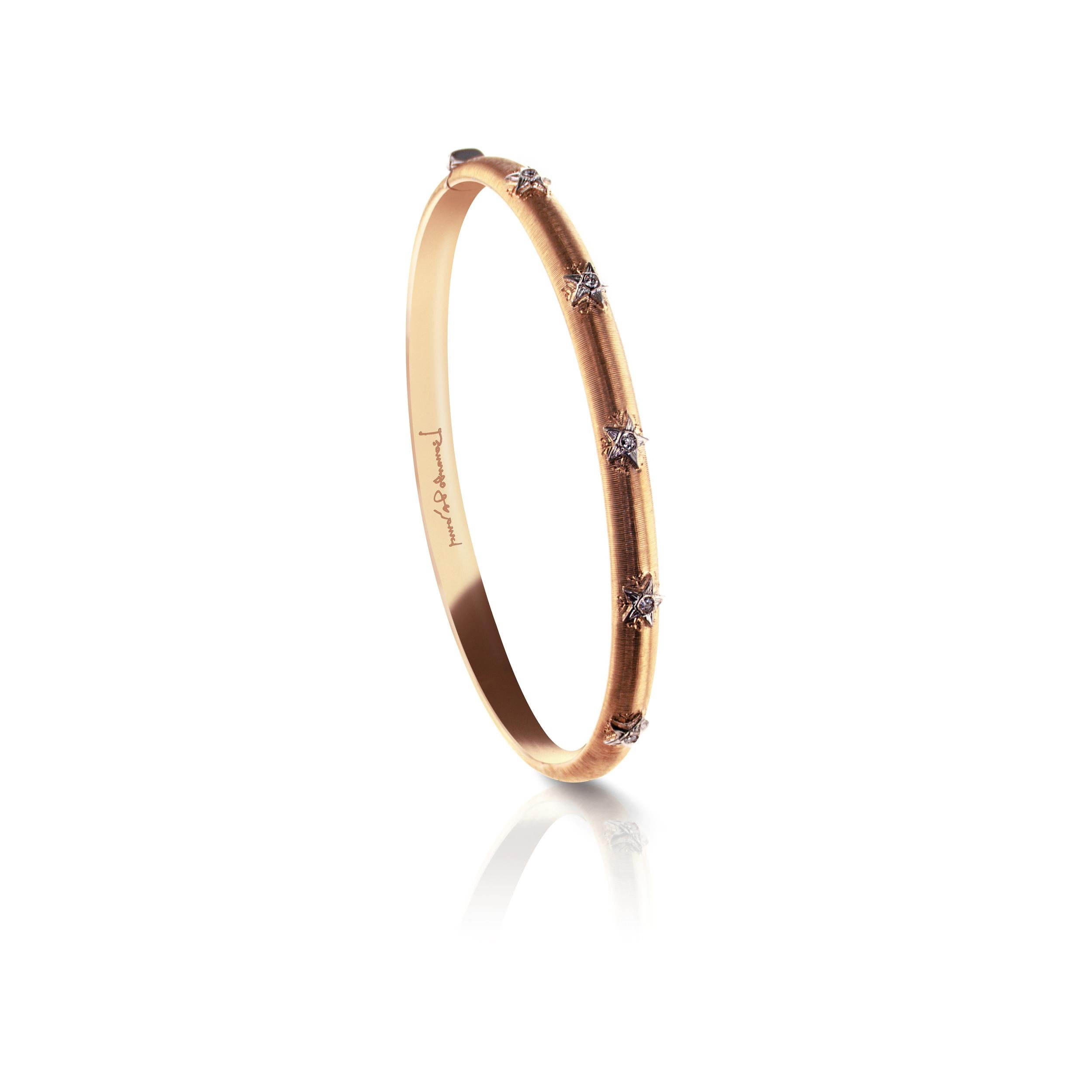 This 18Kt Rose Gold Caterina bangle was designed and inspired by Leonardo da Vinci's architectural drawings.

A thin bangle which is elegantly decorated with 5 white Gold stars on the side of the bangle facing up. Each star holds an internationally