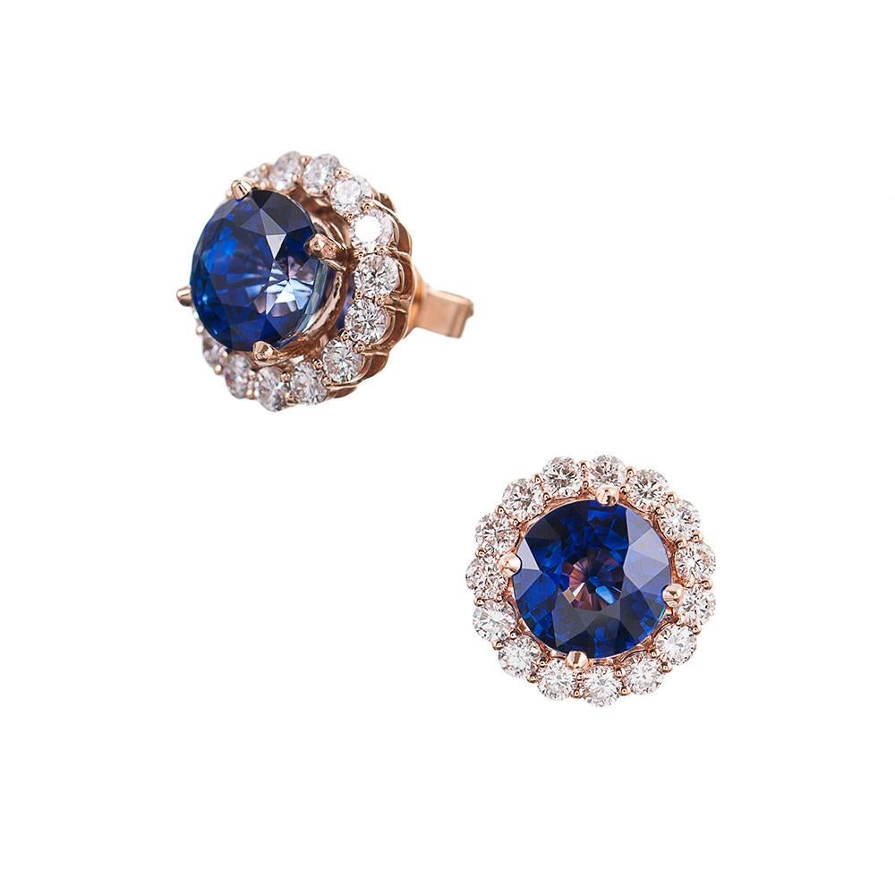 Stunning classic ear studs in a beautiful cluster design with a scalloped border of brilliant white diamonds (1.34 carats in total) surrounding a pair of round Celyon sapphires that weigh 6.04 carats in total. The earrings are made of 18k rose gold,