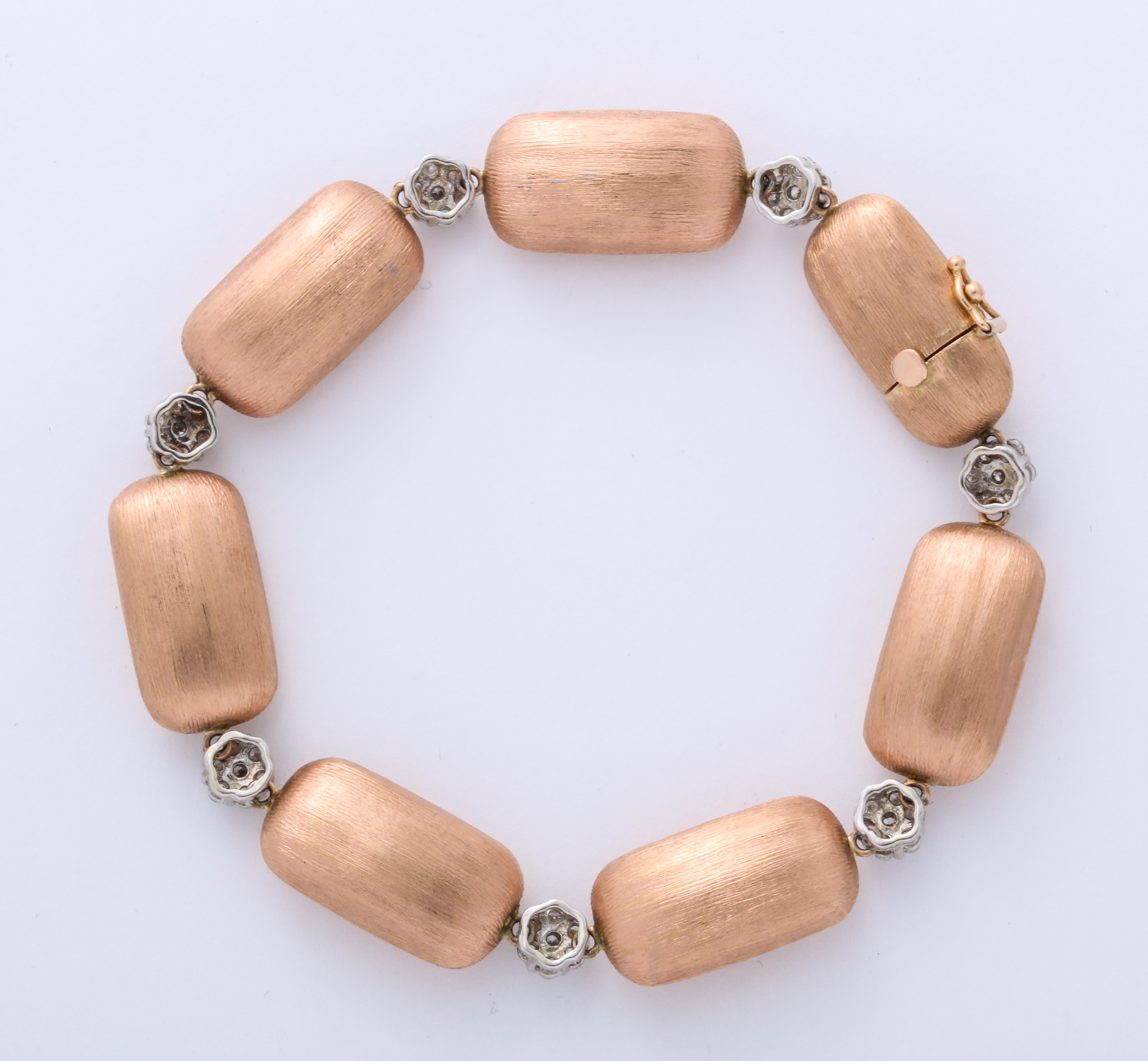 An elegant 18K  rose gold florentine texture bracelet with set diamond spacers between the lozenge 