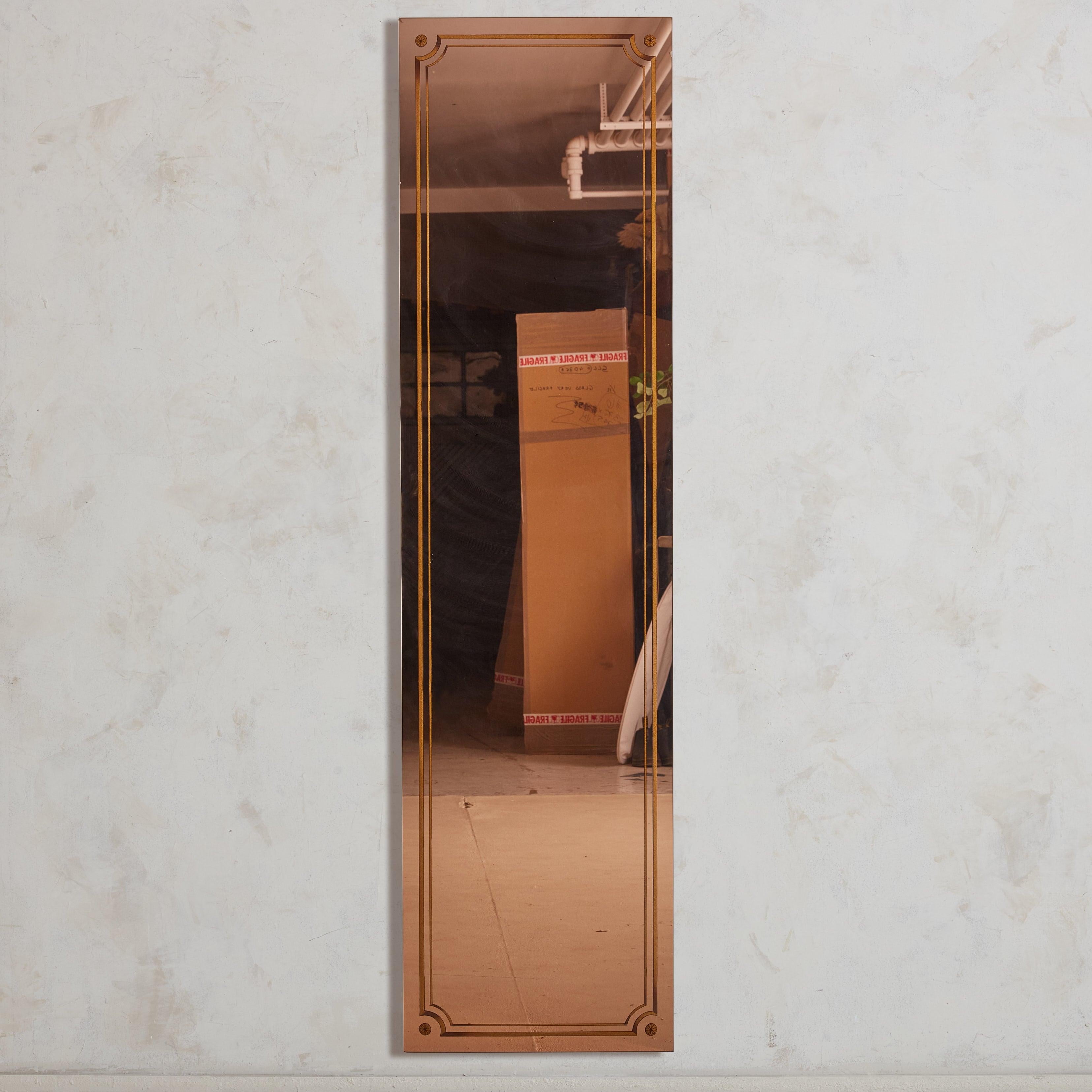 Questo specchio francese in oro rosa, pezzo pregiato degli anni '20, è stato recuperato da una pittoresca e poco illuminata brasserie nel sud della Francia. Il suo design su larga scala è graziosamente delineato da dettagli geometrici dorati che ne