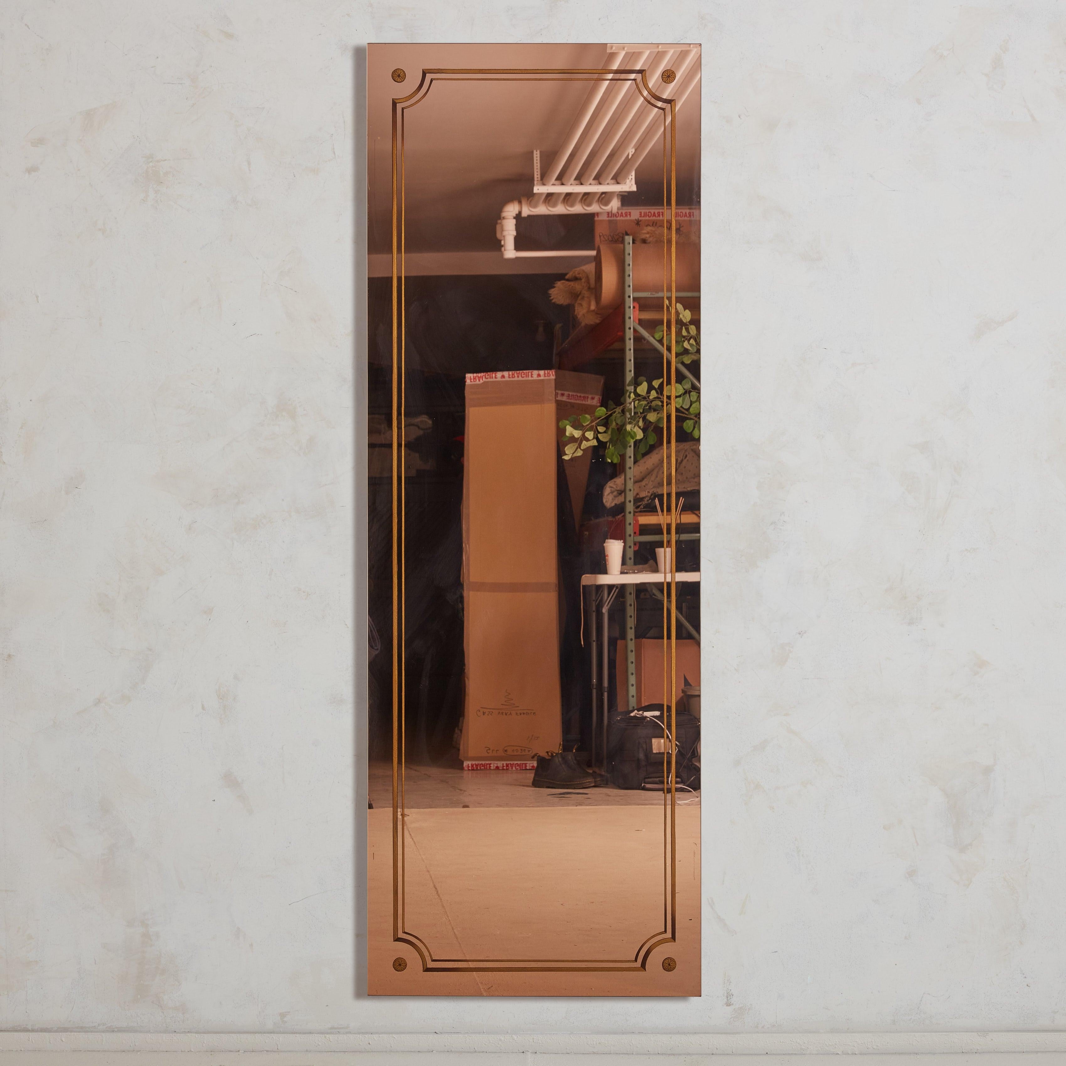 Questo specchio francese in oro rosa, pezzo pregiato degli anni '20, è stato recuperato da una pittoresca e poco illuminata brasserie nel sud della Francia. Il suo design su larga scala è graziosamente delineato da dettagli geometrici dorati che ne