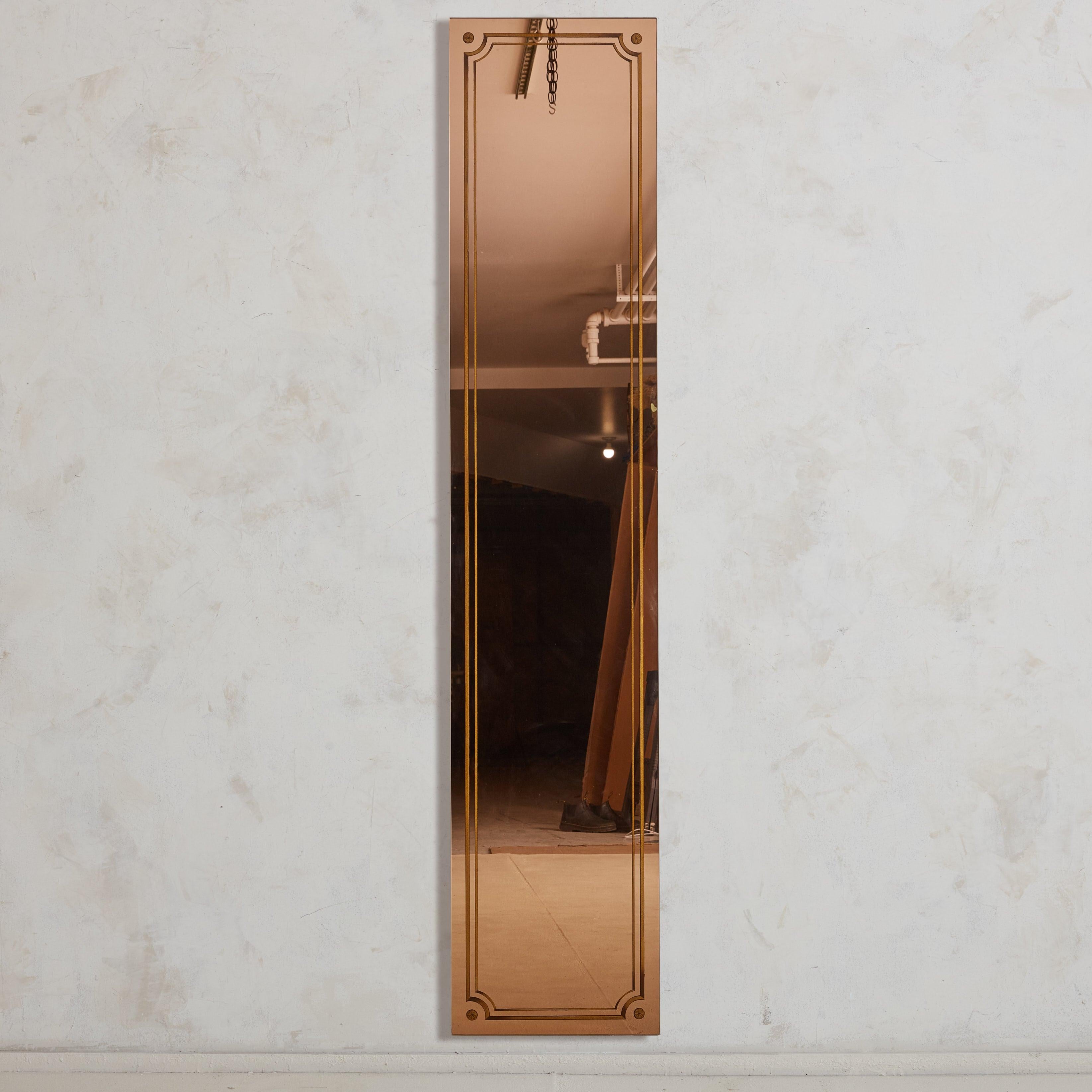 Questo specchio francese in oro rosa, pezzo pregiato degli anni '20, è stato recuperato da una pittoresca e poco illuminata brasserie nel sud della Francia. Il suo design su larga scala è graziosamente delineato da dettagli geometrici dorati che ne