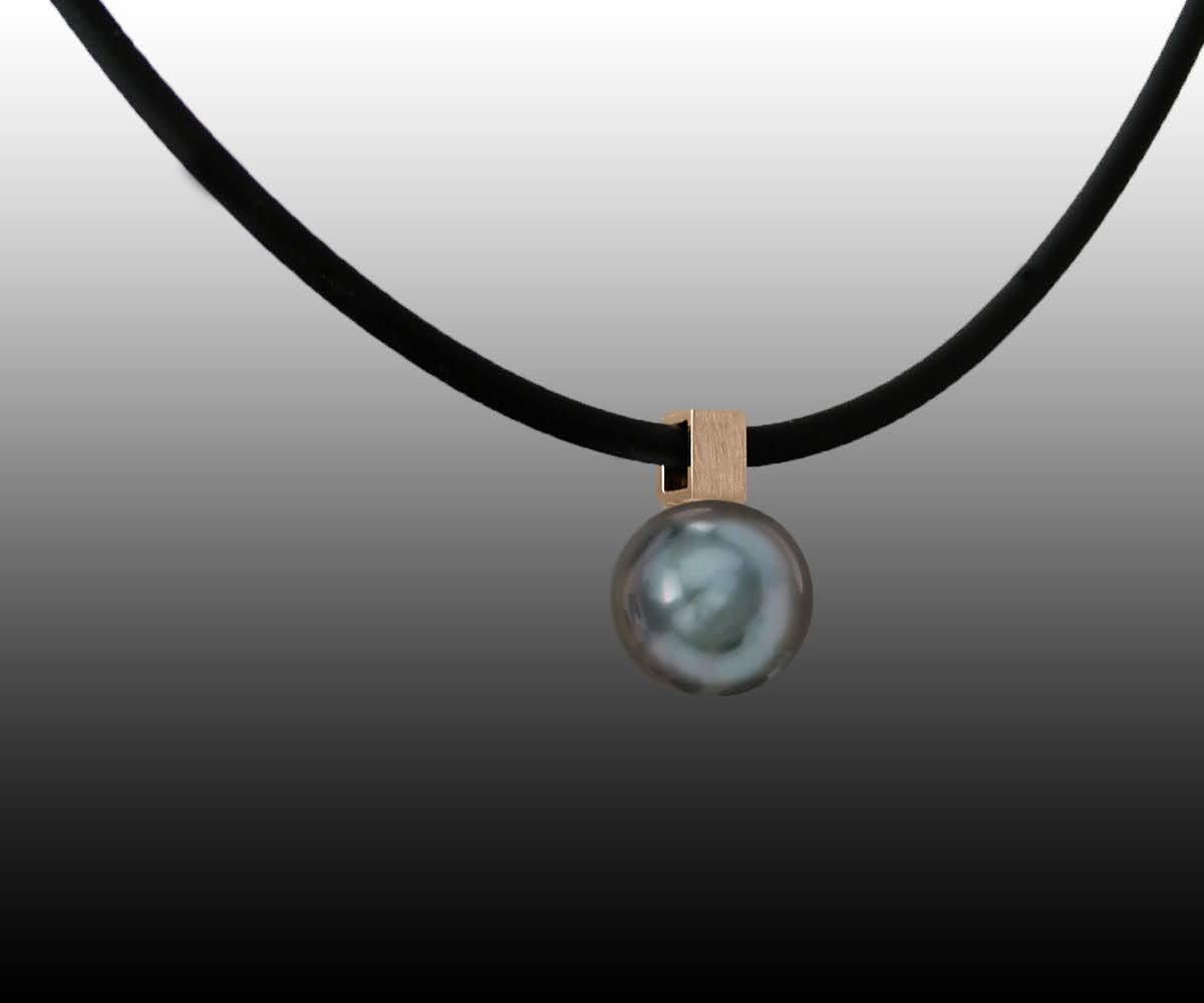 This Rose Gold Bail on Black Tahitian Pearl Pendant on Rubber Cord has a modern edge with the square bail which can hold different chains. It is shown here on a black rubber cord. Pearls are irregular and imperfect each one is unique. The pearls