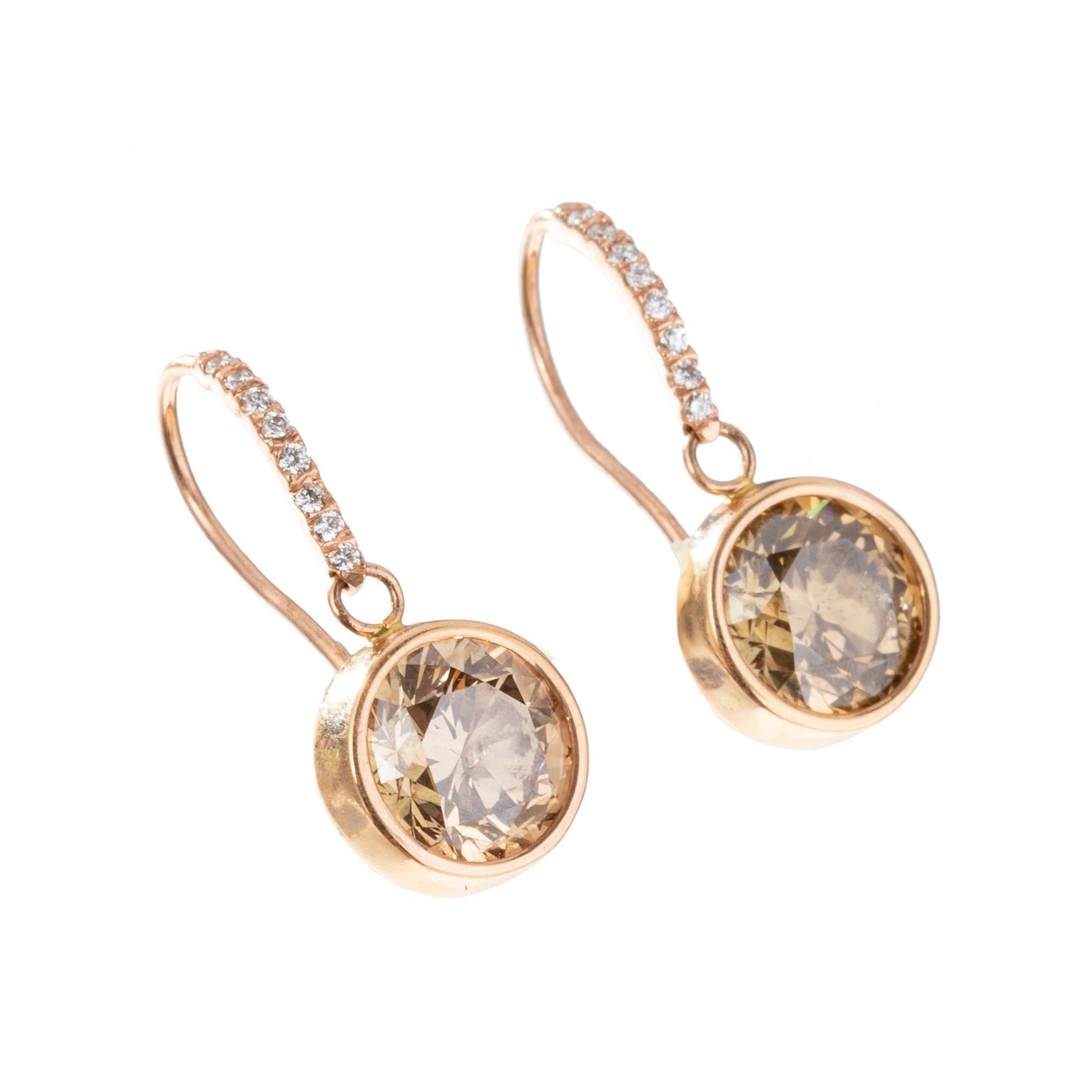 Drop earrings, featuring bezel-set round brilliant-cut brown diamonds suspended from a French wire accented by sixteen small round brilliant cut diamonds.  Handmade in 14k rose gold.  Two brown diamonds weighing approximately 5.00 total carats. 