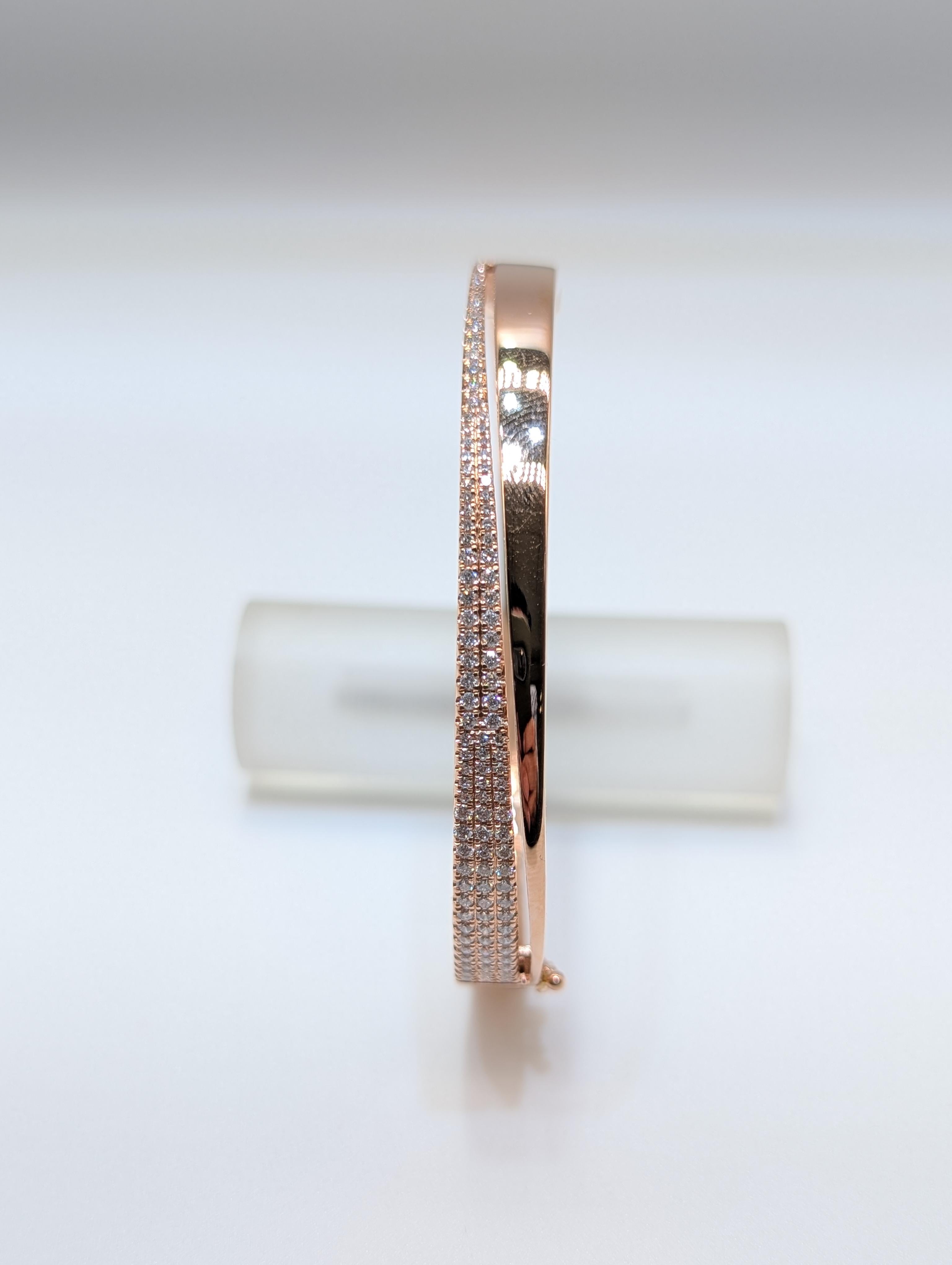 This sophisticated bangle is crafted from 14 grams of rich 14k rose gold, offering a warm and timeless appeal. A graceful wave of round-cut diamonds, totaling 0.78 carats, adds a dazzling touch of brilliance and refined luxury. With its sleek