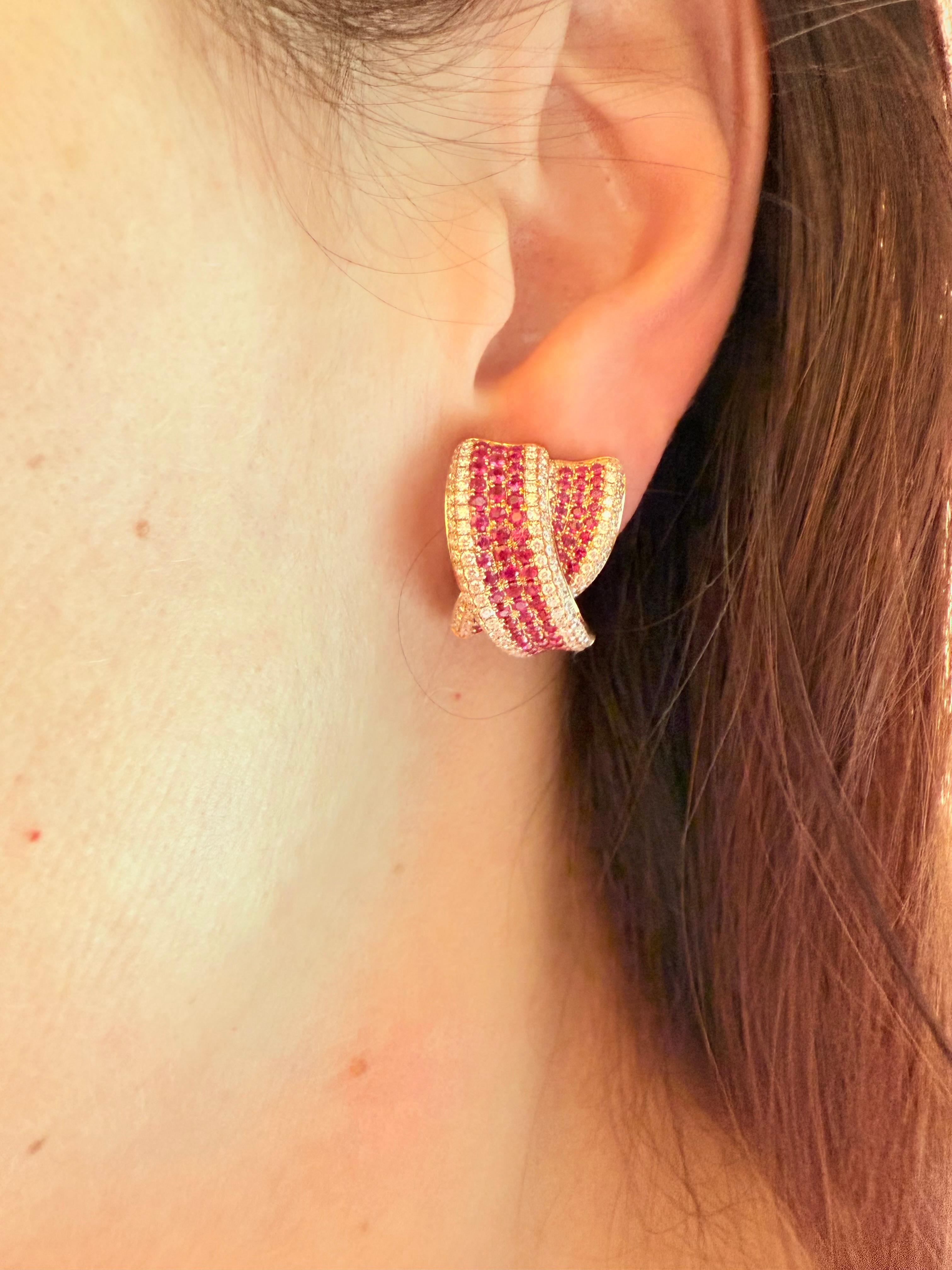 Questi squisiti orecchini sono realizzati in oro rosa 18 carati, che fonde il morbido calore del metallo con la brillantezza dei diamanti naturali e il ricco colore dei rubini pregiati. Il design è completamente incastonato a pavé, con una