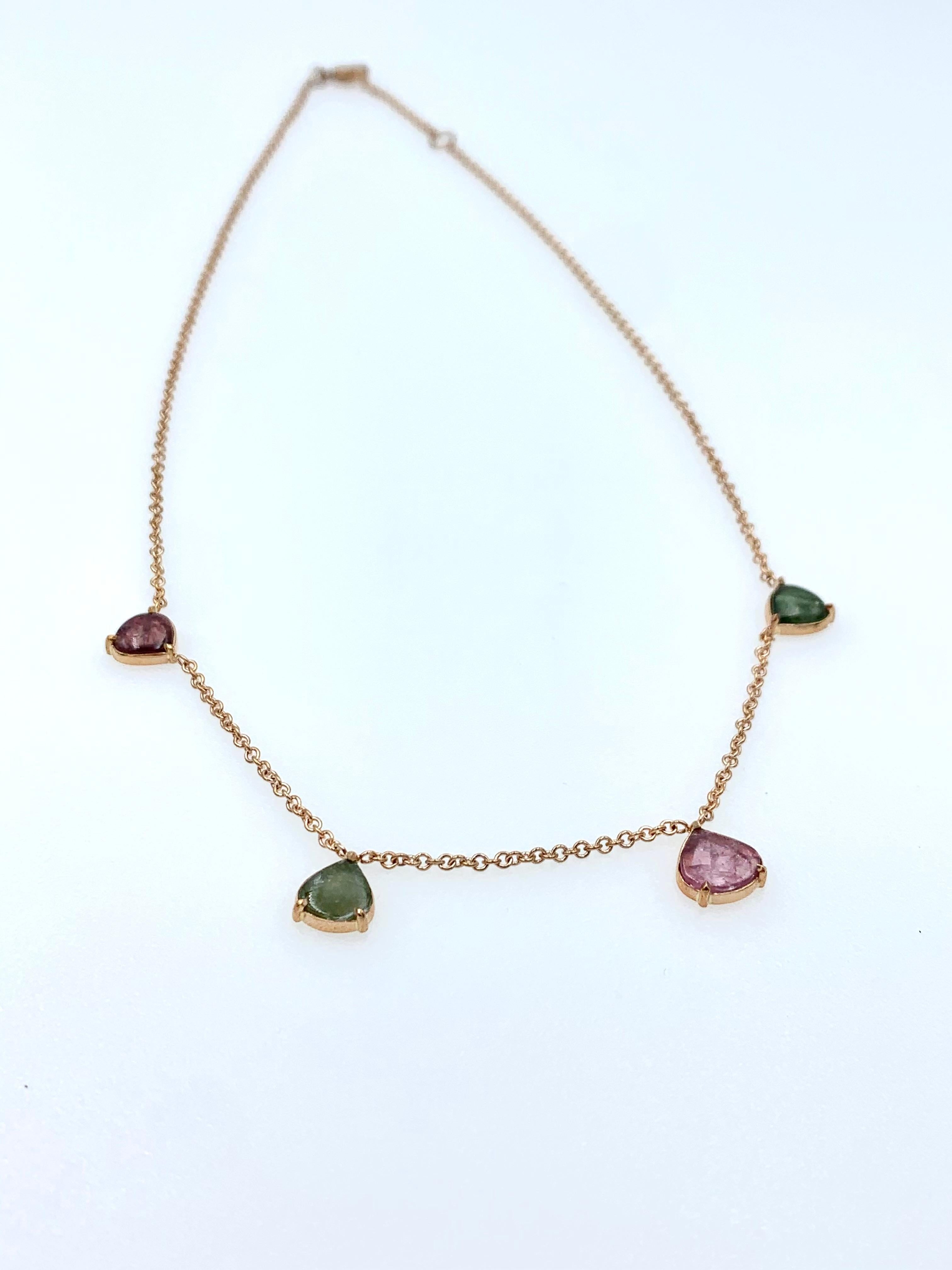 Hand made in 9 karat Rose gold, this chain choker necklace has four stones distributed around the neckline in two different colours: two drop shaped deep green cabochons and two pink drop shaped cabochons. This dainty piece is part of our Ethereal