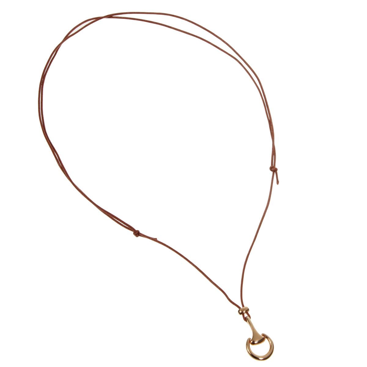 A fine necklace showcasing an 18k rose gold horsebit motif suspended by a brown leather cord adjustable up to 30