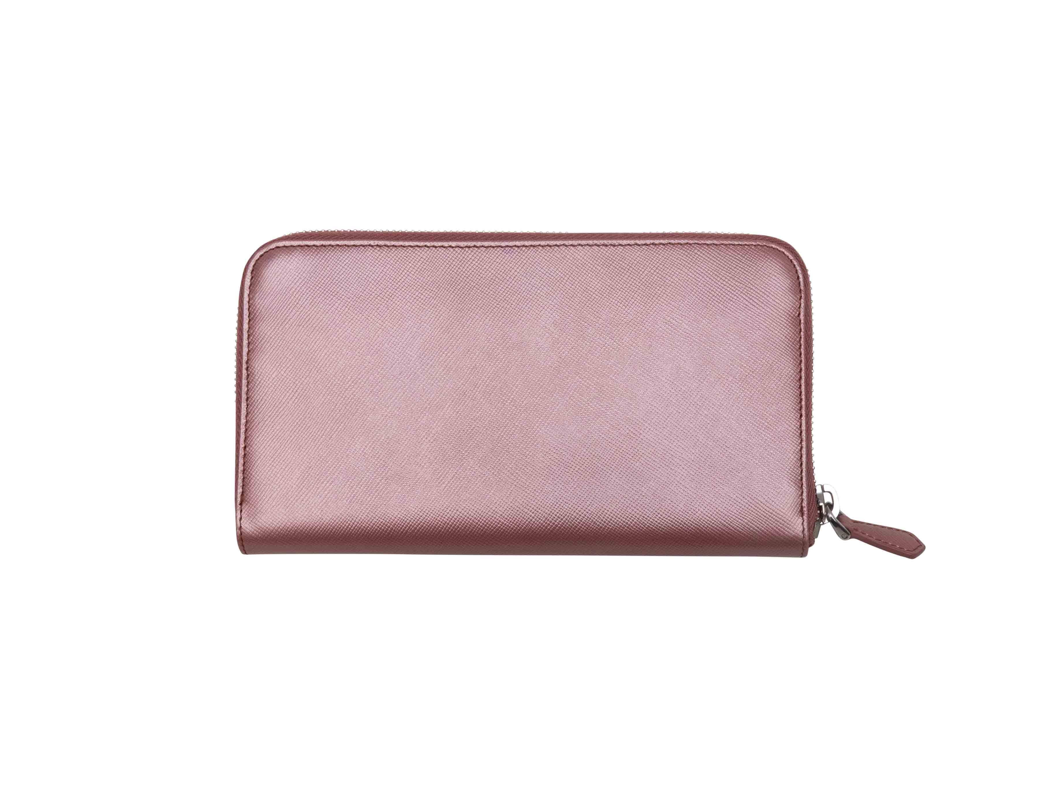 Rose gold Saffiano leather continental zip wallet by Prada. Silver-tone hardware. Multiple interior card and cash slots. Zip closure at exterior. 0.75