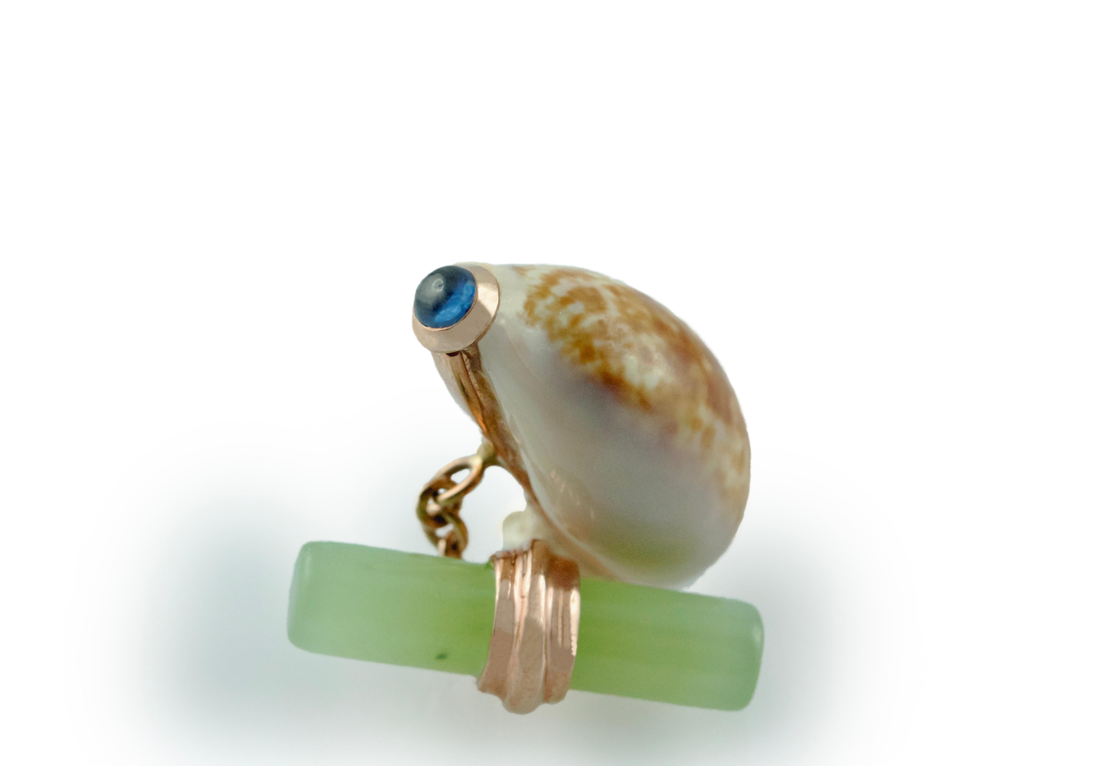 These exquisite cufflinks combine the majesty of nature with masterful craftsmanship. Their front face is a  shell, boasting its natural pattern in neutral colors and adorned at the top with a sapphire mounted in rose gold. The post is made of the