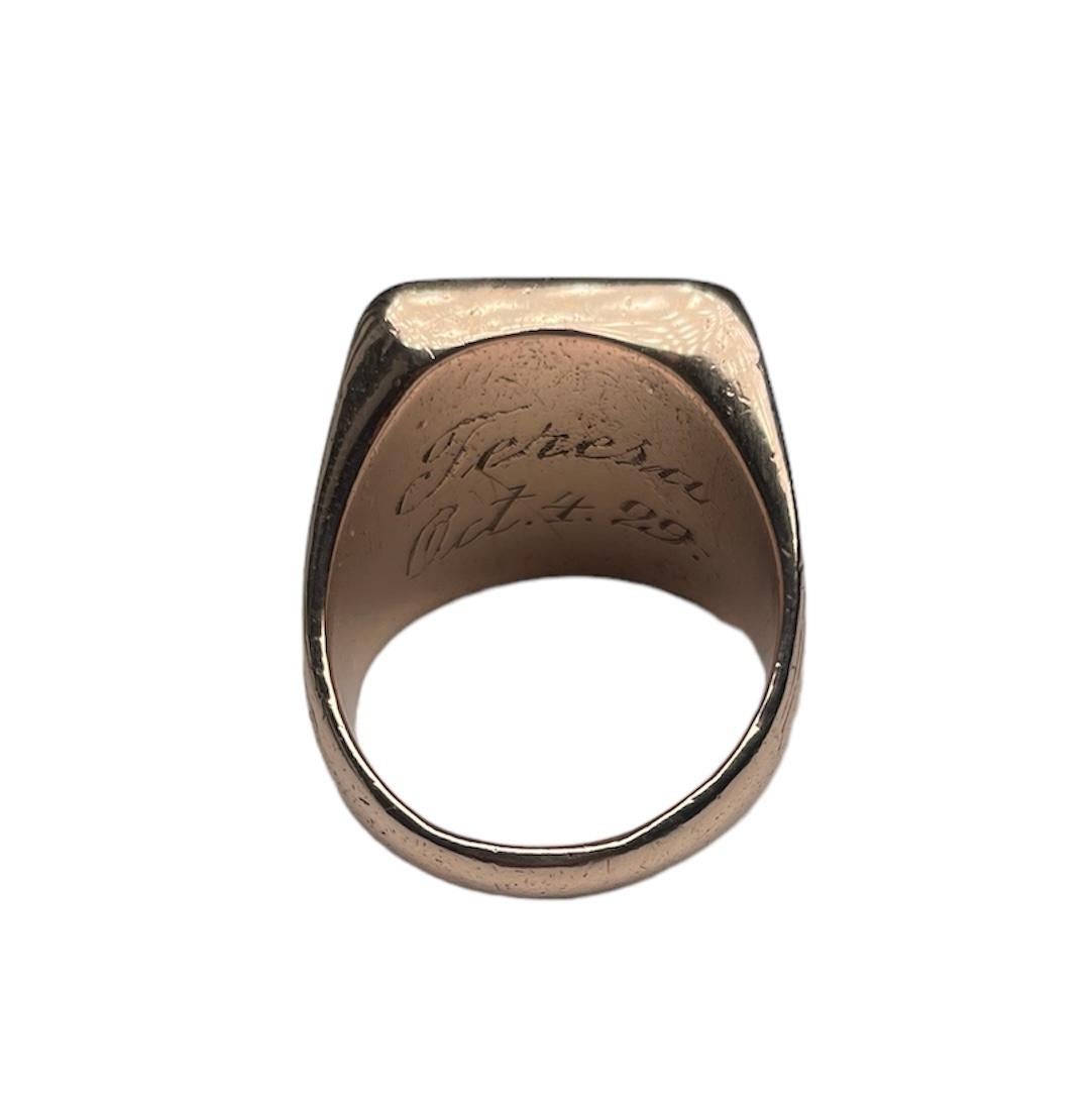 This is a Rose Gold Ring. It depicts a heavy gold ring with a rectangular shape top made to personalize a family crest, coat of arms or any creative design. The wide shanks of the ring are engraved with a large palm branch. The ring is not