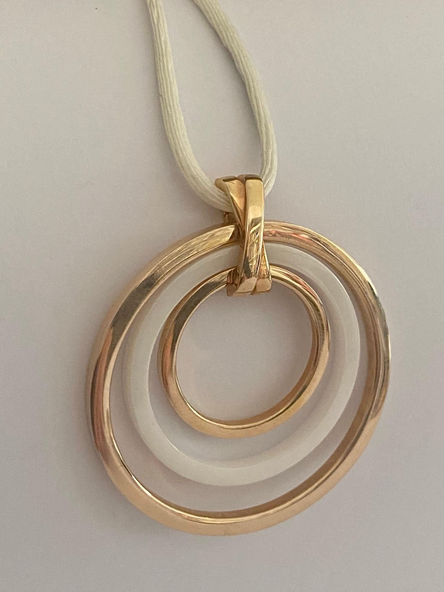 A 14K. rose gold pendant consisting of:
2 rose gold rings, 1 white cermic ring and a rose gold clip closure. A white silk necklace with a rose gold (14K) clasp.
Signed: Elaine Firenze = Italy.
Total weight: 11.58 grams
necklace length: 42 cm.
size