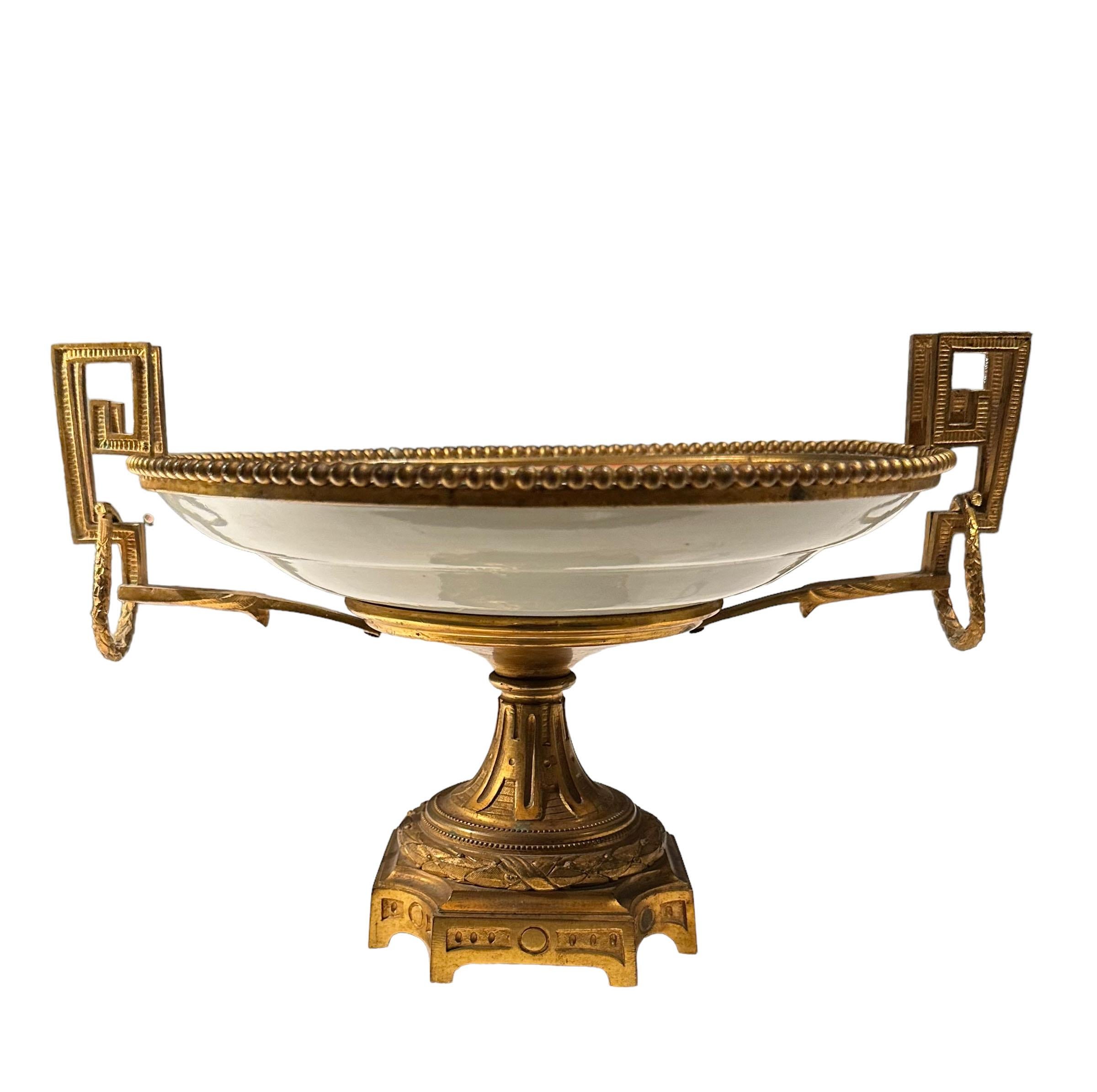 Un piatto in porcellana rosa mandarino del XIX secolo incastonato in una Taza francese in bronzo dore con maniglie a chiave greca. Ottima qualità. Il piatto ha un diametro di nove pollici. 
