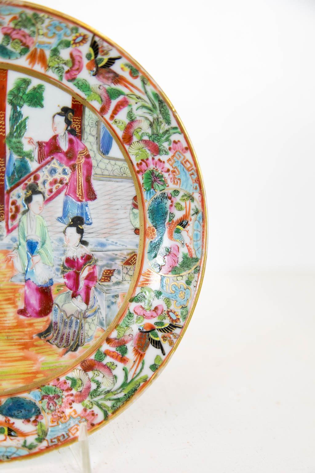 This plate has a center with Mandarin court scenes framed by a border of birds, butterflies, and leaf and floral decorations. It is in mint condition.