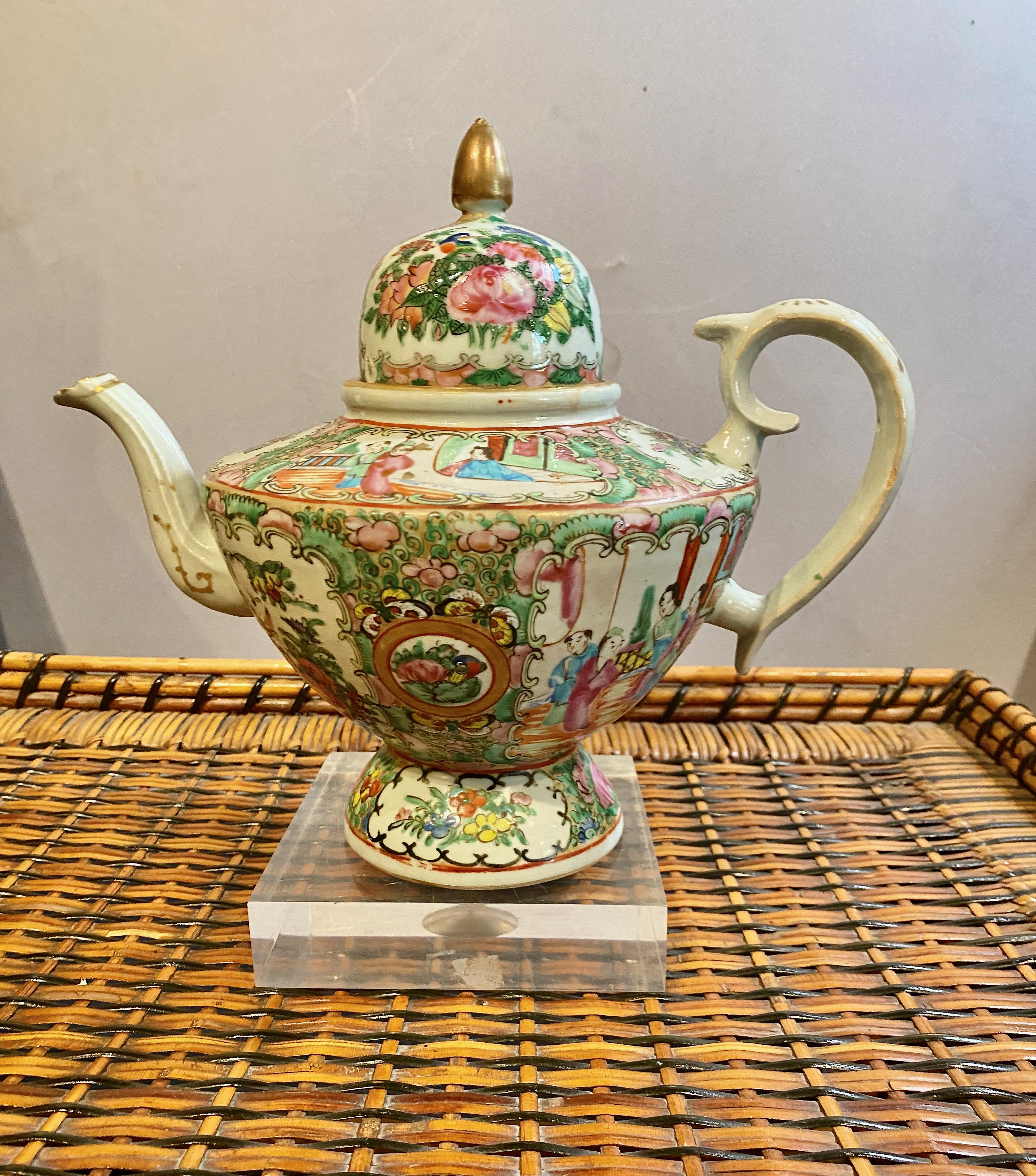 This is a charming antique mid-19th century Chinese Export Rose Medallion Teapot. The form of the teapot was modeled after English silver teapots of the period. The teapot is in overall very good condition. There is an under-edge chip to the deep