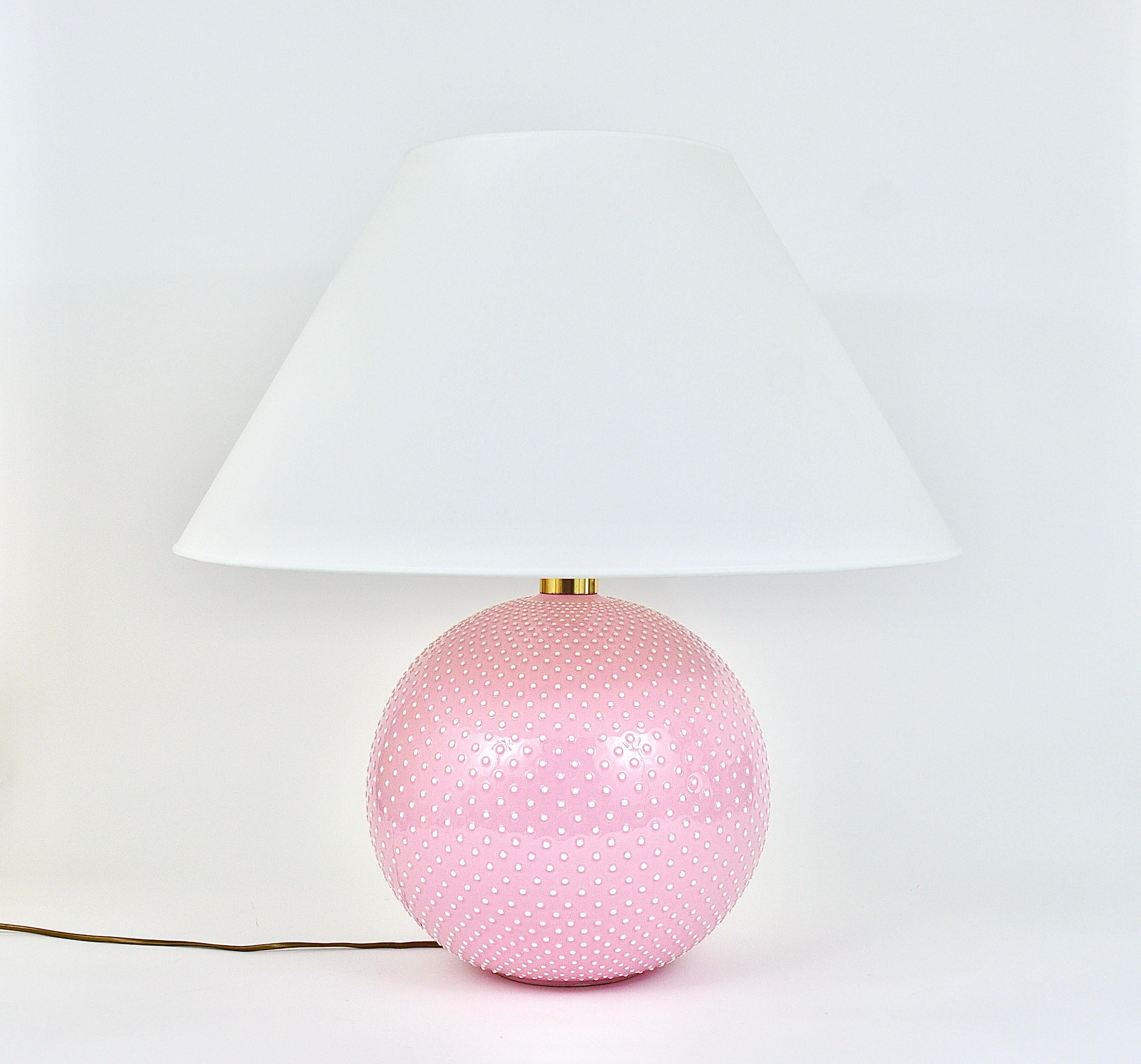 A lovely and large spherical Midcentury table or side lamp from the 1970s, executed by Studio PAF Milano, Italy. Its base is made of shiny glazed ceramic and brass and it has an amazing textured polka dot relief surface in pastel pink and white. The