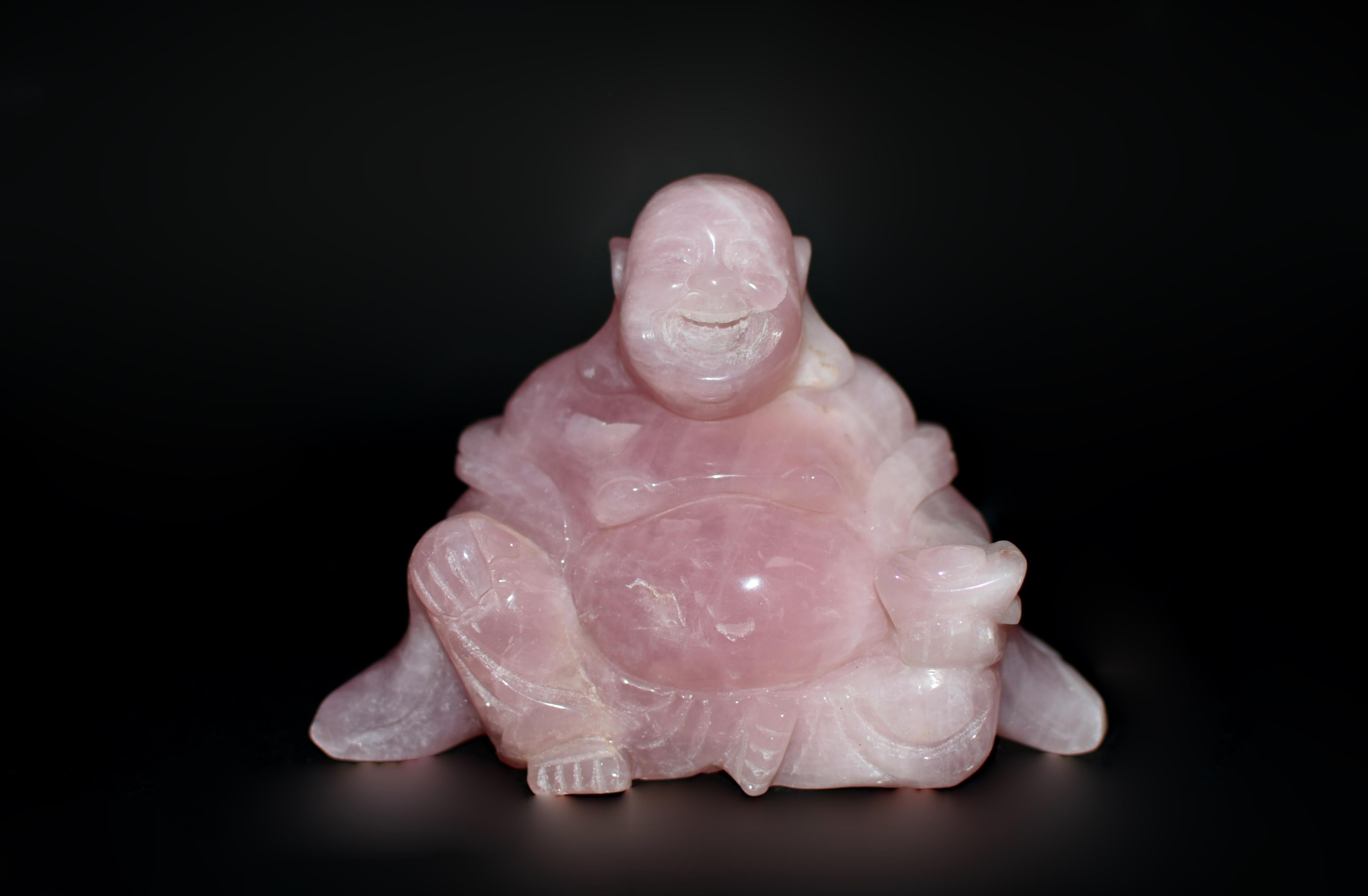 Carved from the purest grade of Madagascar rose quartz, this wonderful Happy Buddha statue radiates warmth and joy. With meticulous attention to detail, the master artisan has captured the Happy Buddha in a state of boundless mirth. Long earlobes
