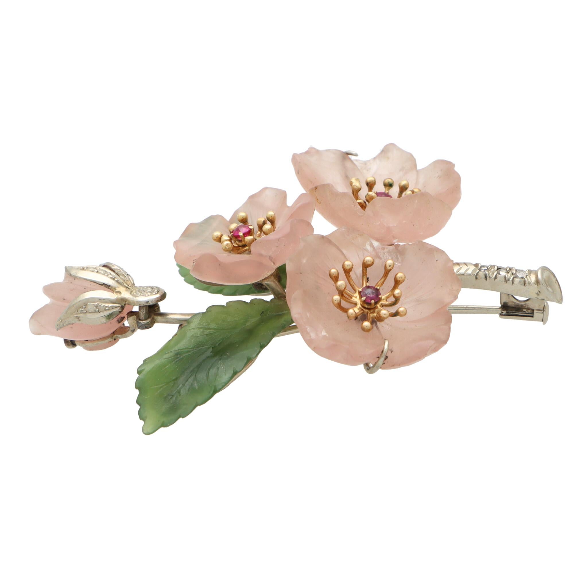 A highly unique rose quartz, nephrite, ruby and diamond floral spray brooch set in 14k white gold.

This beautifully crafted piece is designed as a floral spray and is predominantly set with three intricately hand carved rose quartz flowers. Each