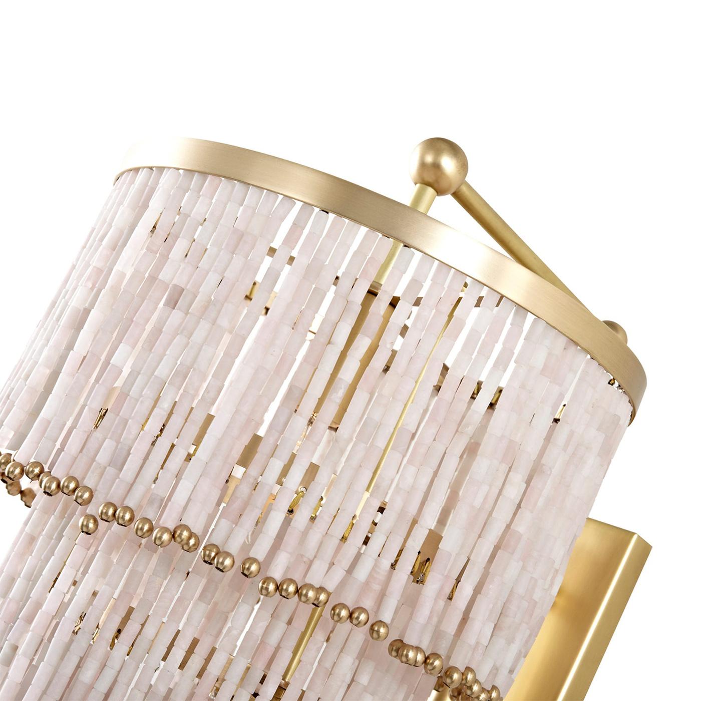 Este elegante aplique de pared adornado con cuentas de cuarzo rosa capta a la perfección el equilibrio entre lujo y artesanía que define a Badari. El delicado diseño artesanal del aplique añade un toque sofisticado a cualquier interior, creando un
