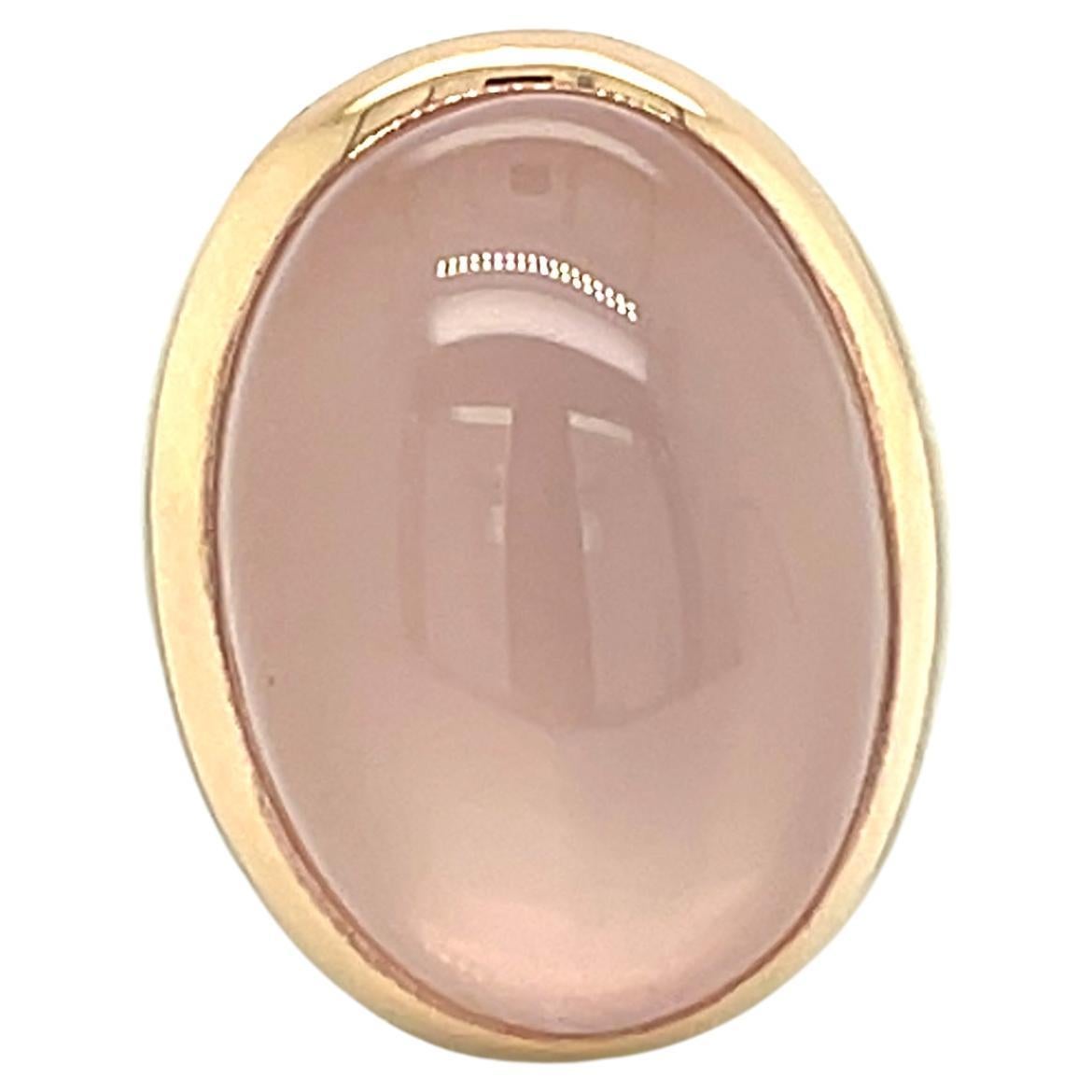 Enhance your hand with this stunning 18-carat rose gold ring, designed with soft curves and gentle elegance. At its heart sits a 10.45-carat rose quartz, cut in an oval cabochon, delicately catching the light with its tender and soothing