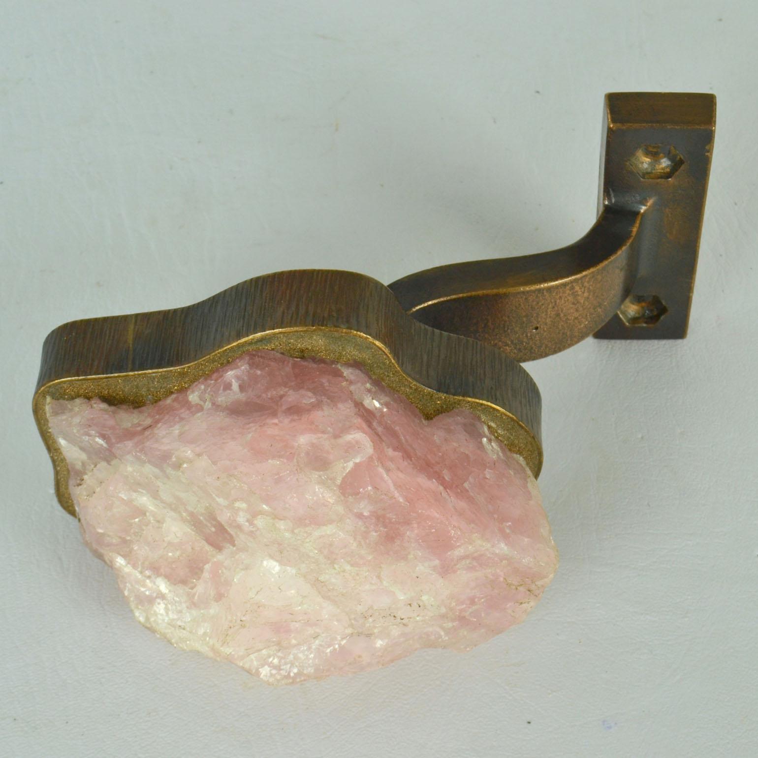 Rose Quartz and Bronze push and pull door handle, made from a semi precious stone in soft pink, set into a bronze holder that follows its natural shape and is made to measure. It is a piece of jewelry for your door.
The handle is attached to a