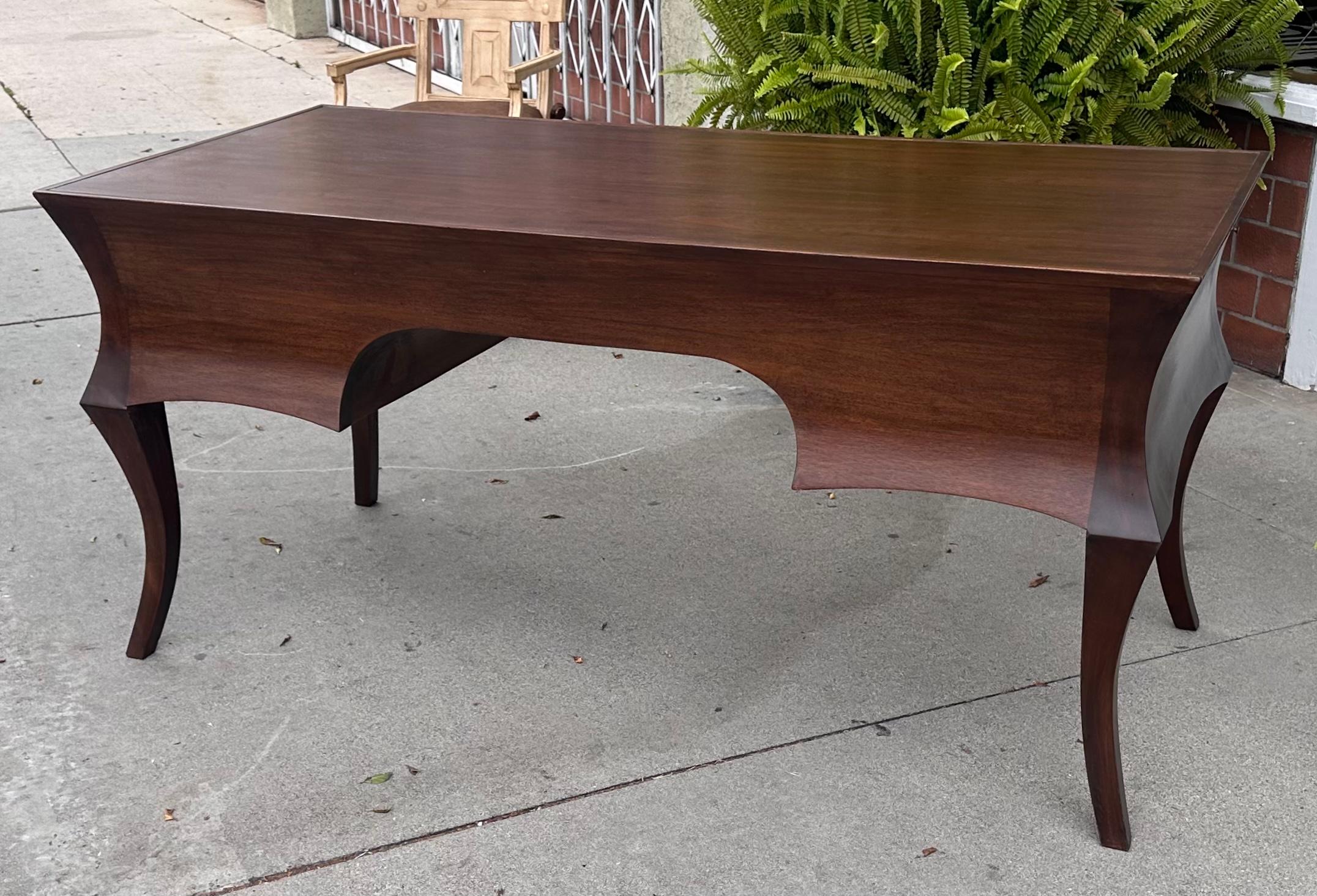 Rose Tarlow Melrose House Cyrano Writing Table Desk. it features Five drawers and pull out platforms on either side. The drawer pulls are a variant bronze oval.