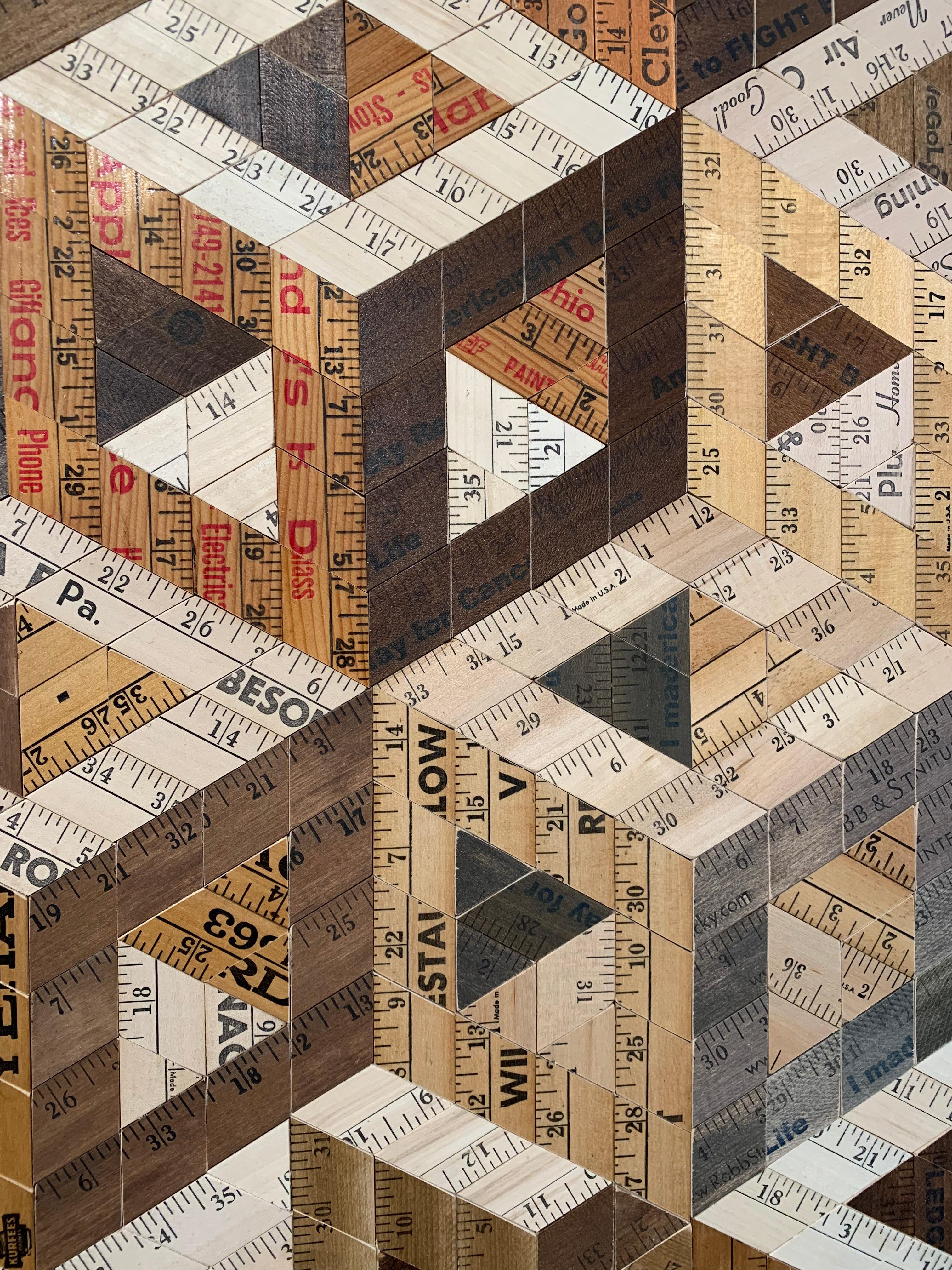 Descending Cube by Rose Vickers. 

Medium: recycled yardsticks & rulers. 

Since completing her degree in Applied Arts, Rose has exhibited widely and worked on a broad range of public and private commissions. Her chosen medium consists of found and