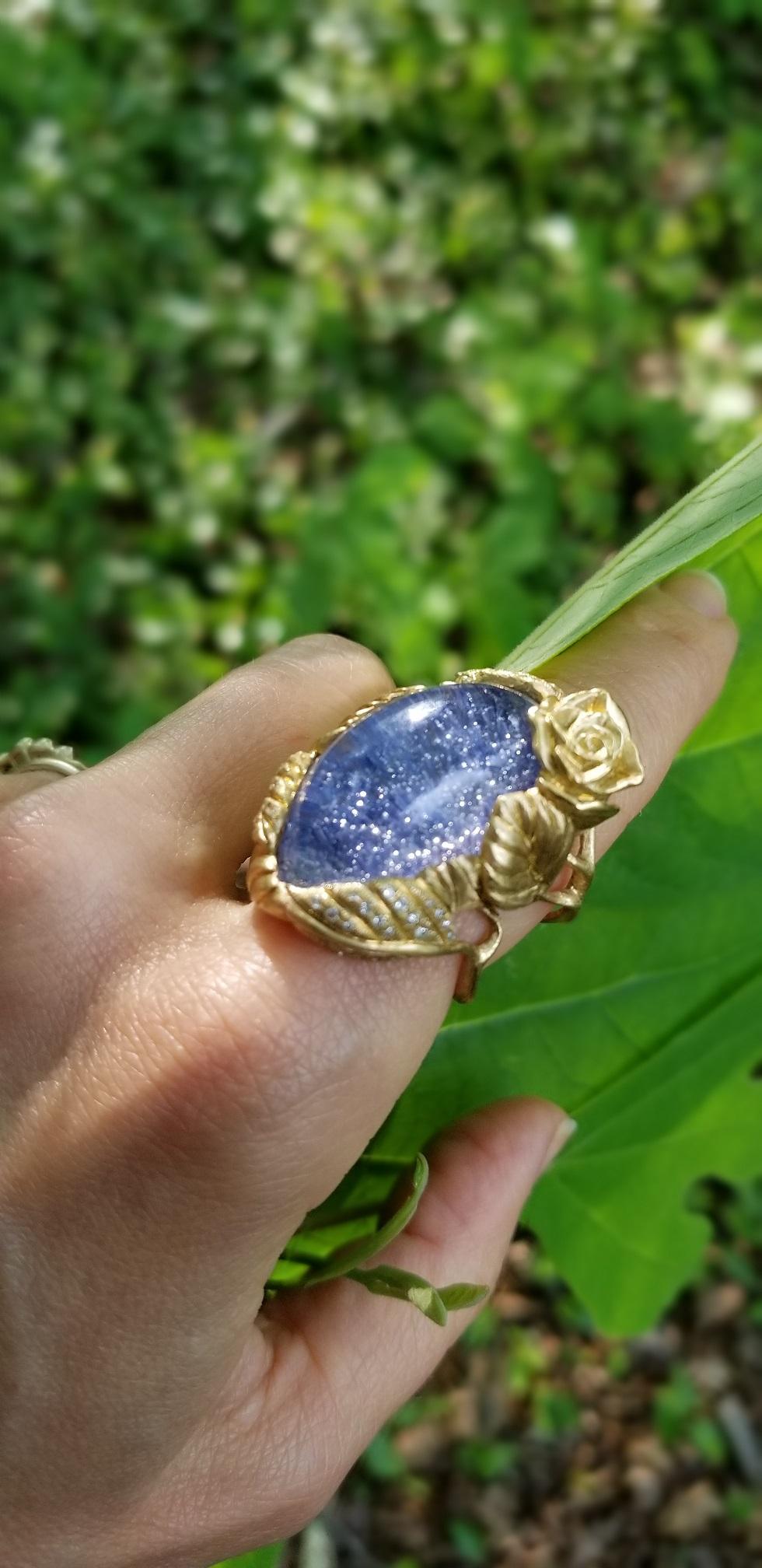 One-of-a-kind, 18k yellow gold, dumortierite in quartz, diamonds

Nestled in a bed of roses, this one-of-a-kind Dumortierite gemmy dew-drop glistens, revealing a universe of sparkling stars reflected in the blue water.
The 18k recycled yellow gold