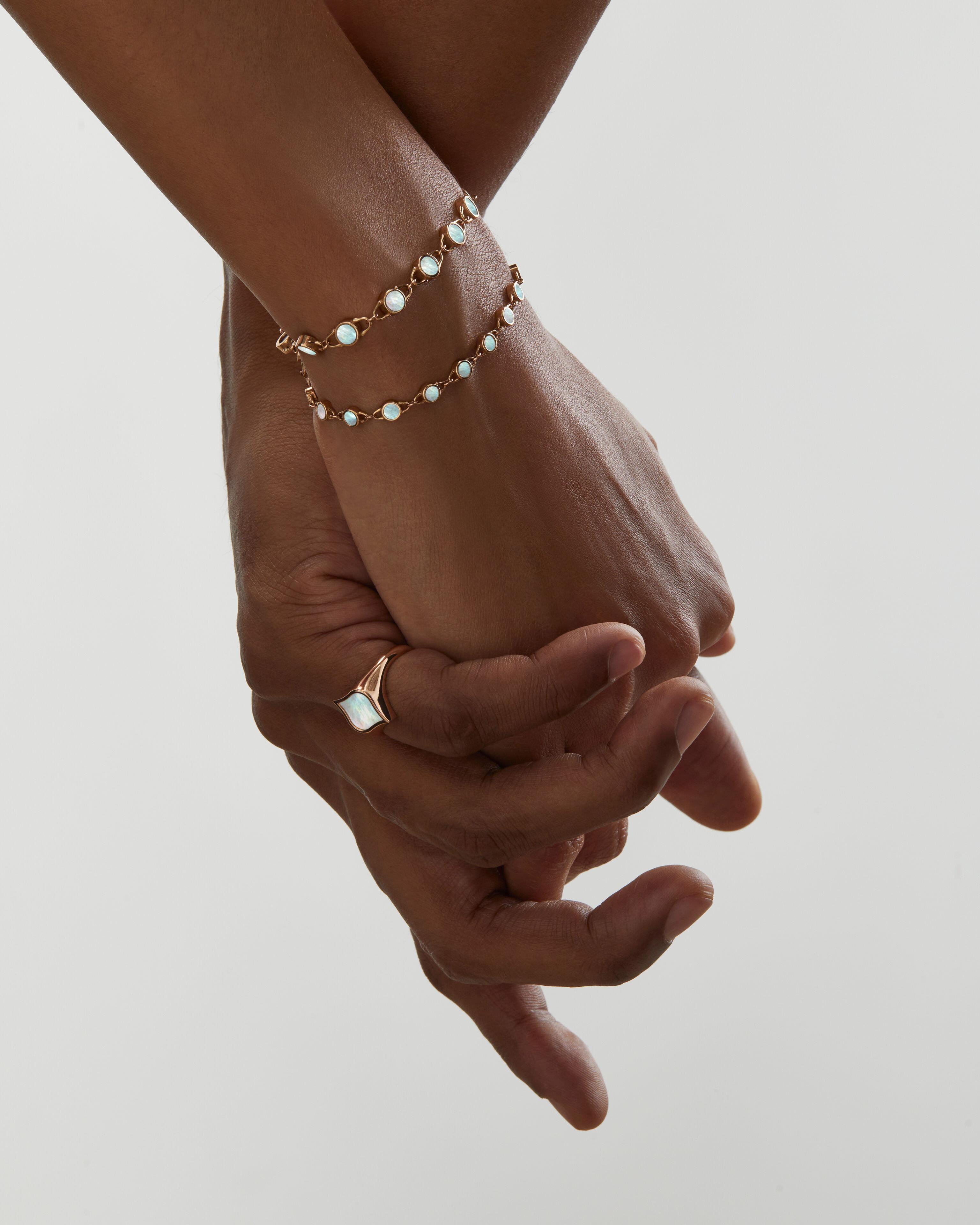 A new tennis bracelet: a sculptural yet delicate chain bracelet with carved mother-of-pearl disks and open links in 18k rose gold. This innovative system connects the structure of padlocks and the fluidity of water drops. The clasp is distinguished