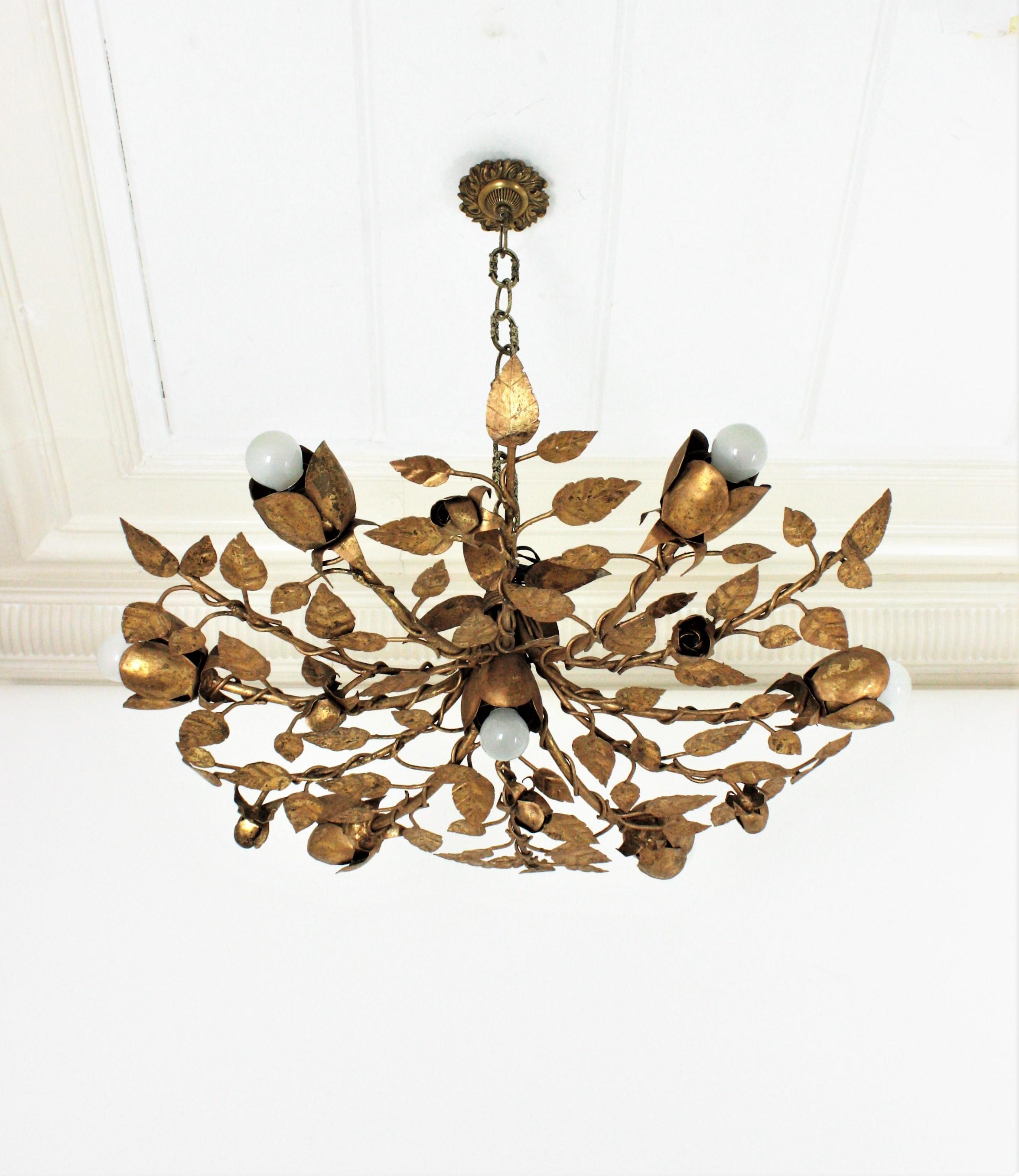 Outstanding large size gilt iron ornate foliage flower bush ceiling sconce or flushmount with seven rose shaped light holders. Spain, 1960s.
This seven-light ceiling lamp features an intrincate of branches with leaves in different sizes adorned by