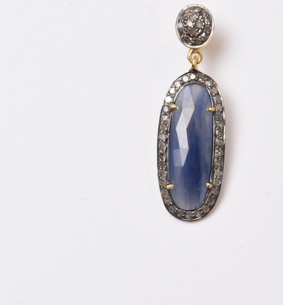 Rosecut blue sapphire oval slices as found in their natural state and then cut and polished, bordered with diamonds set in oxidized sterling silver.  Post is 18K gold for pierced ears, also with diamonds.  Total carat weight of sapphires is 14