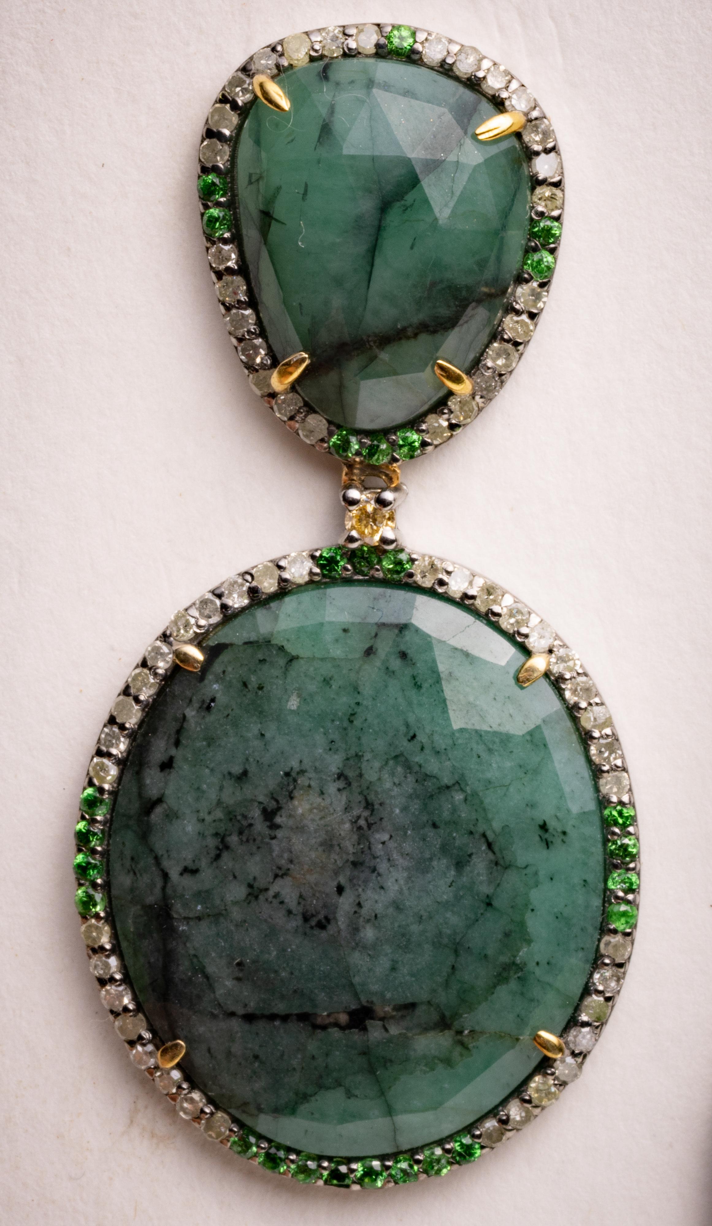 A pair of double drop, sliced rosecut emerald  gemstones bordered with pave`-set, round brilliant-cut diamonds and tsavorite gems.  Emeralds total 25.82 carats, diamonds total 1.26 carats and the tsavorite gems total .45 carats.  Set in sterling