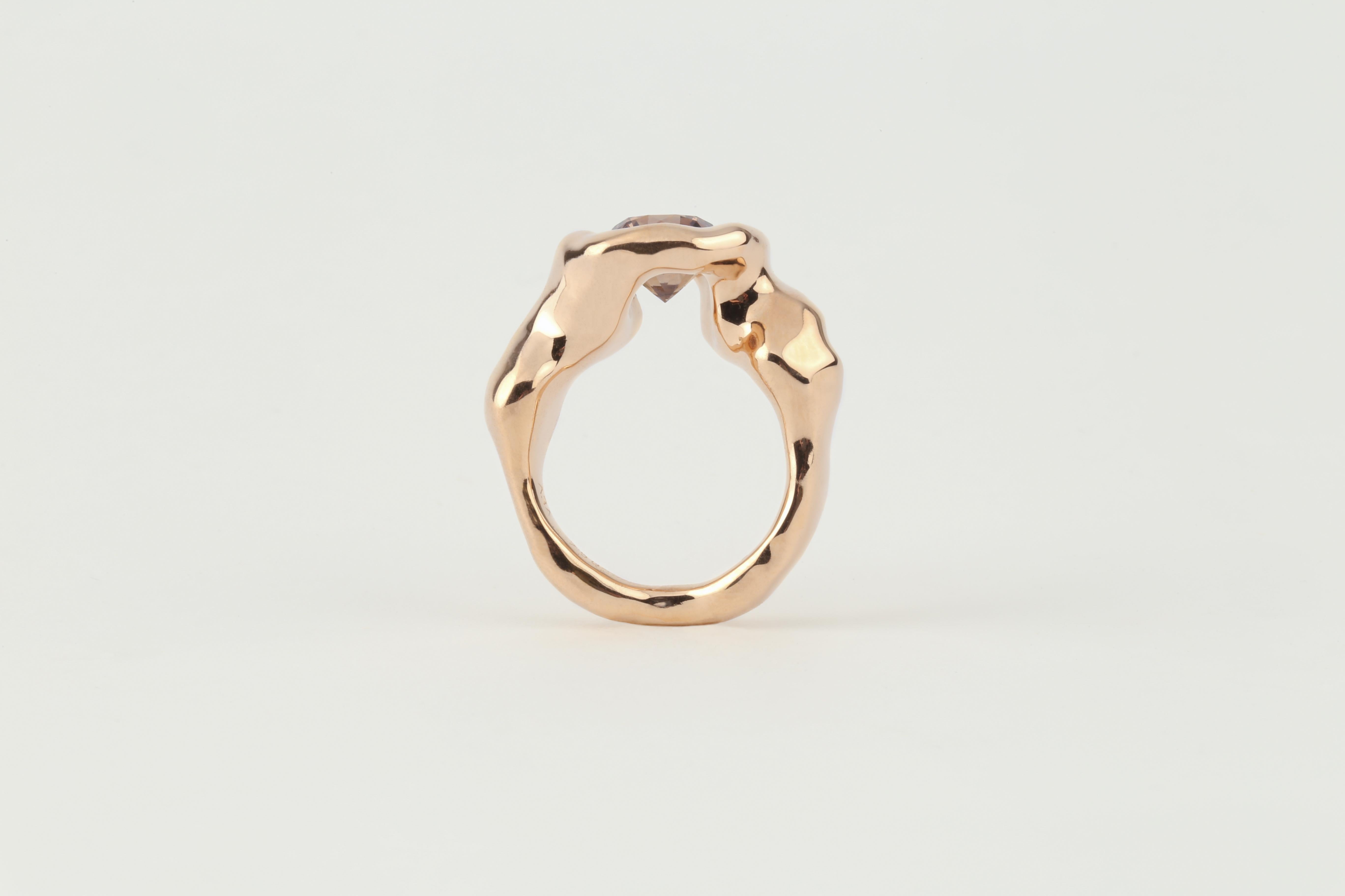 This ring is made of Rosegold (750/- or 18 karat) and has a melted structure. The 3 ct. big brown diamond matches the colour of the gold perfectly. The forms details allow to see the lower part of the diamond, so you can discover the ring like a