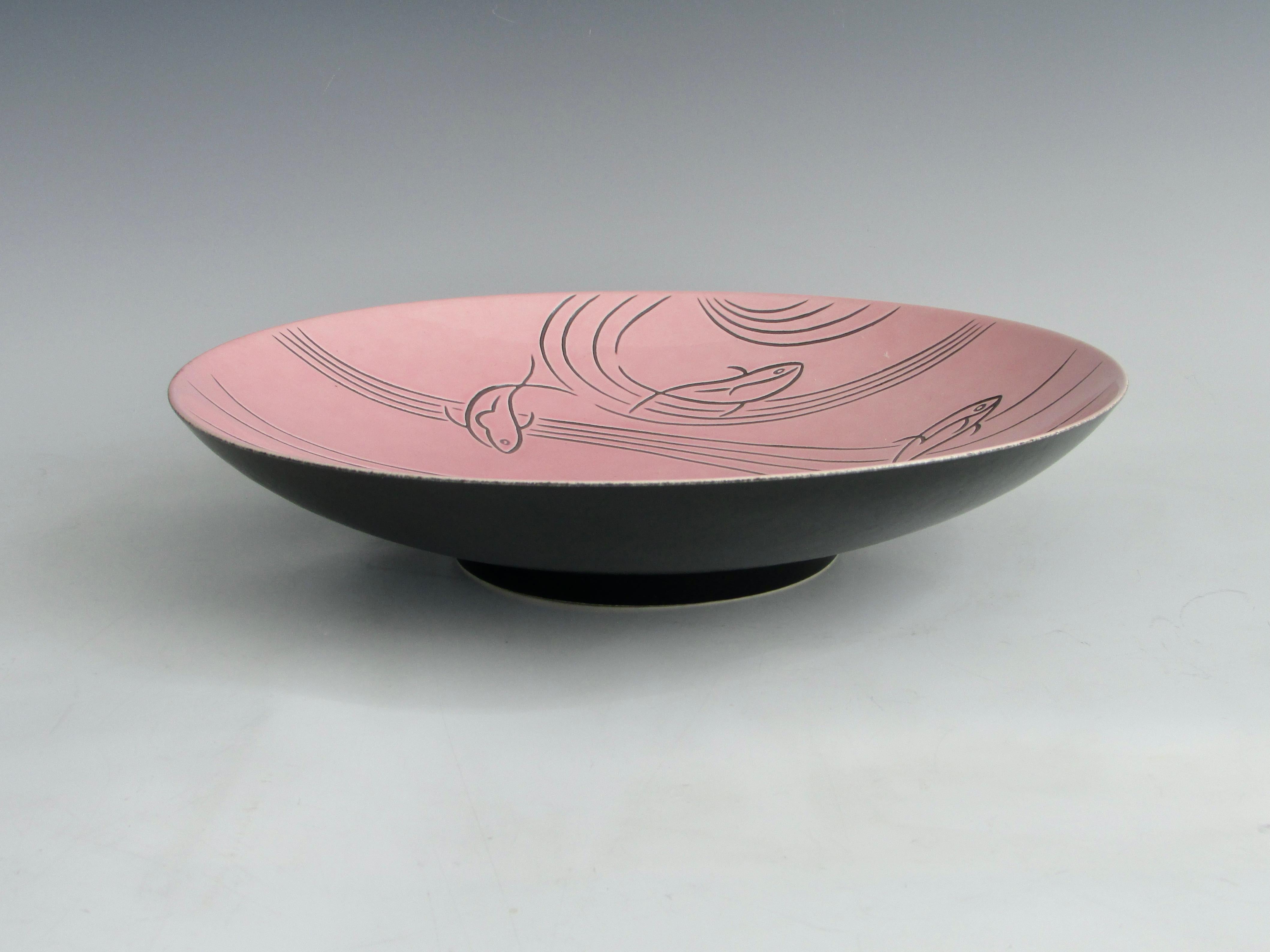 Pink glazed Roselane pottery bowl with free form swirl and Fish Design in black . Exterior of bowl in matte black finish stamped Roselane on underside. Produced by Roselane pottery of Pasadena Ca.