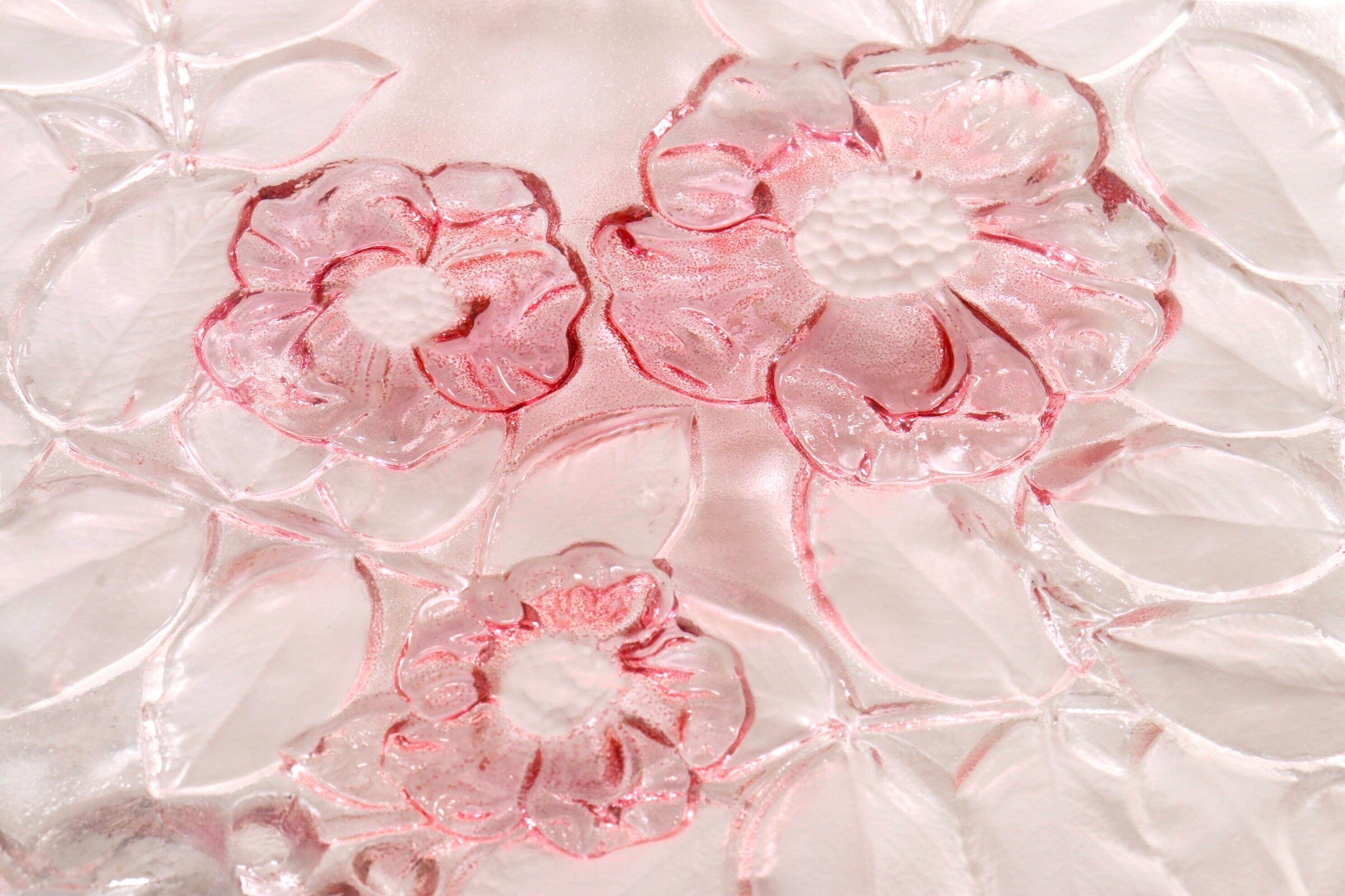 A decorative glass plate in the Rosella pattern made by Mikasa of New Jersey. Frosted glass is etched with roses on the underside and decorated in pink, surrounded by delicate foliage. Pink glass ribbon handles adorn each side. 